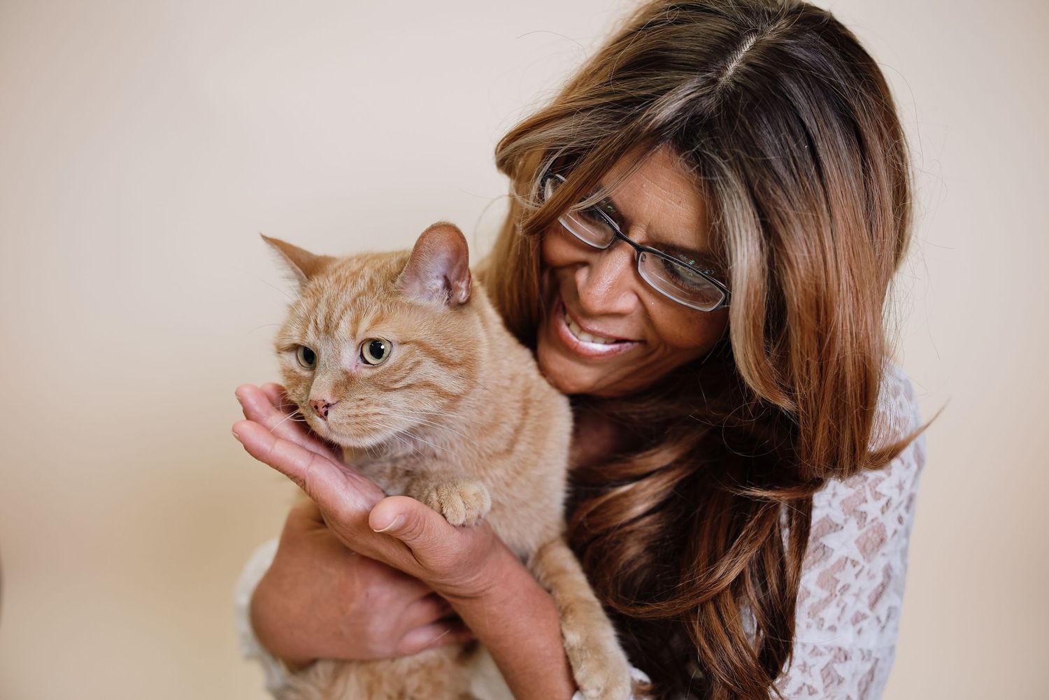 A series of photos showing a ginger cat being held and cuddled while making expressive faces.