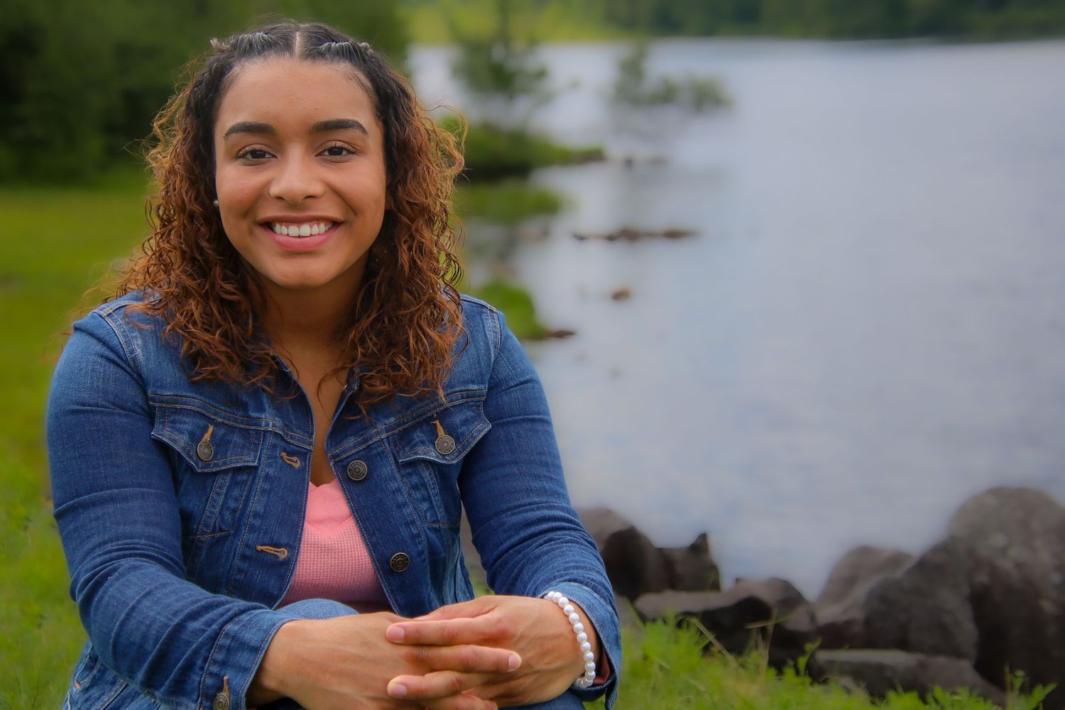 A collage of four photos shows someone in a denim jacket sitting by a scenic waterfront on a sunny day.