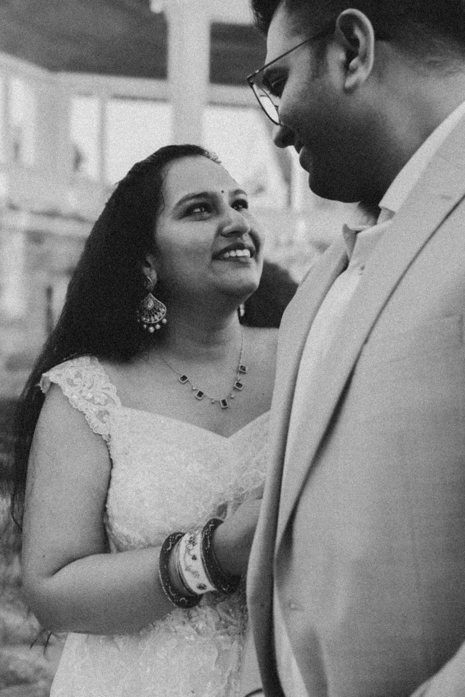 Black and white wedding photos showing romantic moments between a bride in lace dress and groom in light suit.