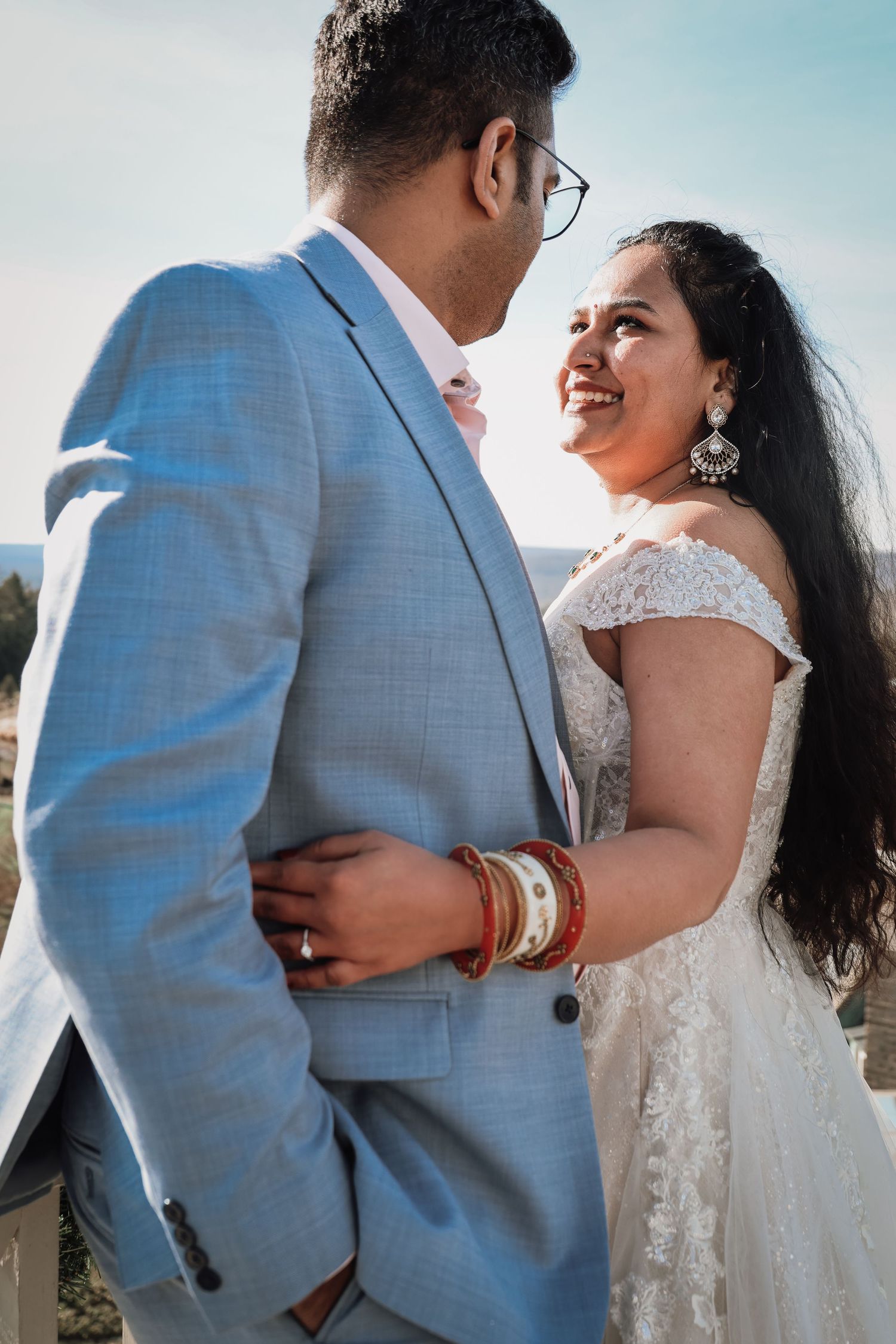 A series of romantic wedding photos showing a couple embracing outdoors in light blue suit and white lace dress.