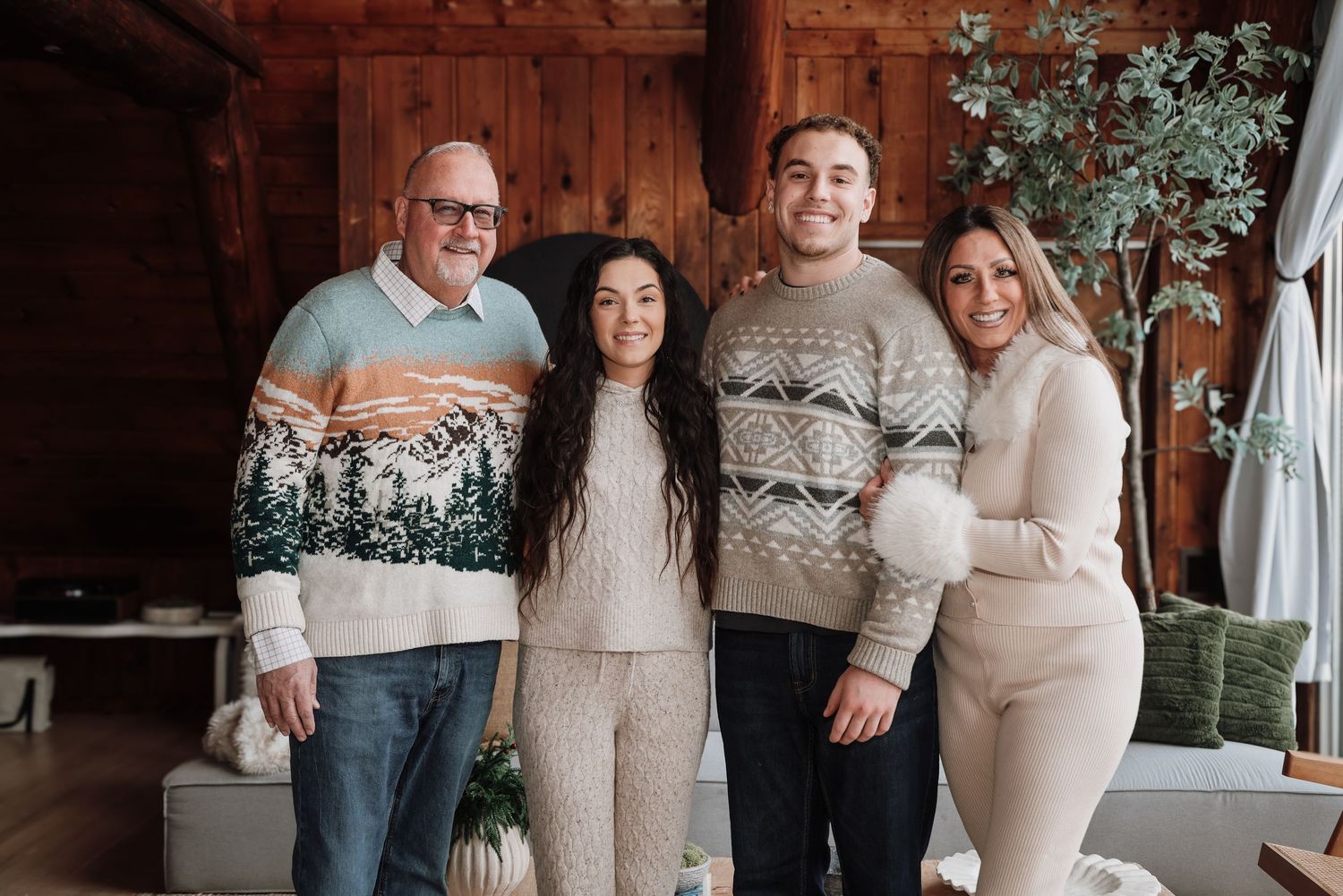 A group photo series in a rustic barn setting with matching cream and gray sweaters against wooden walls.