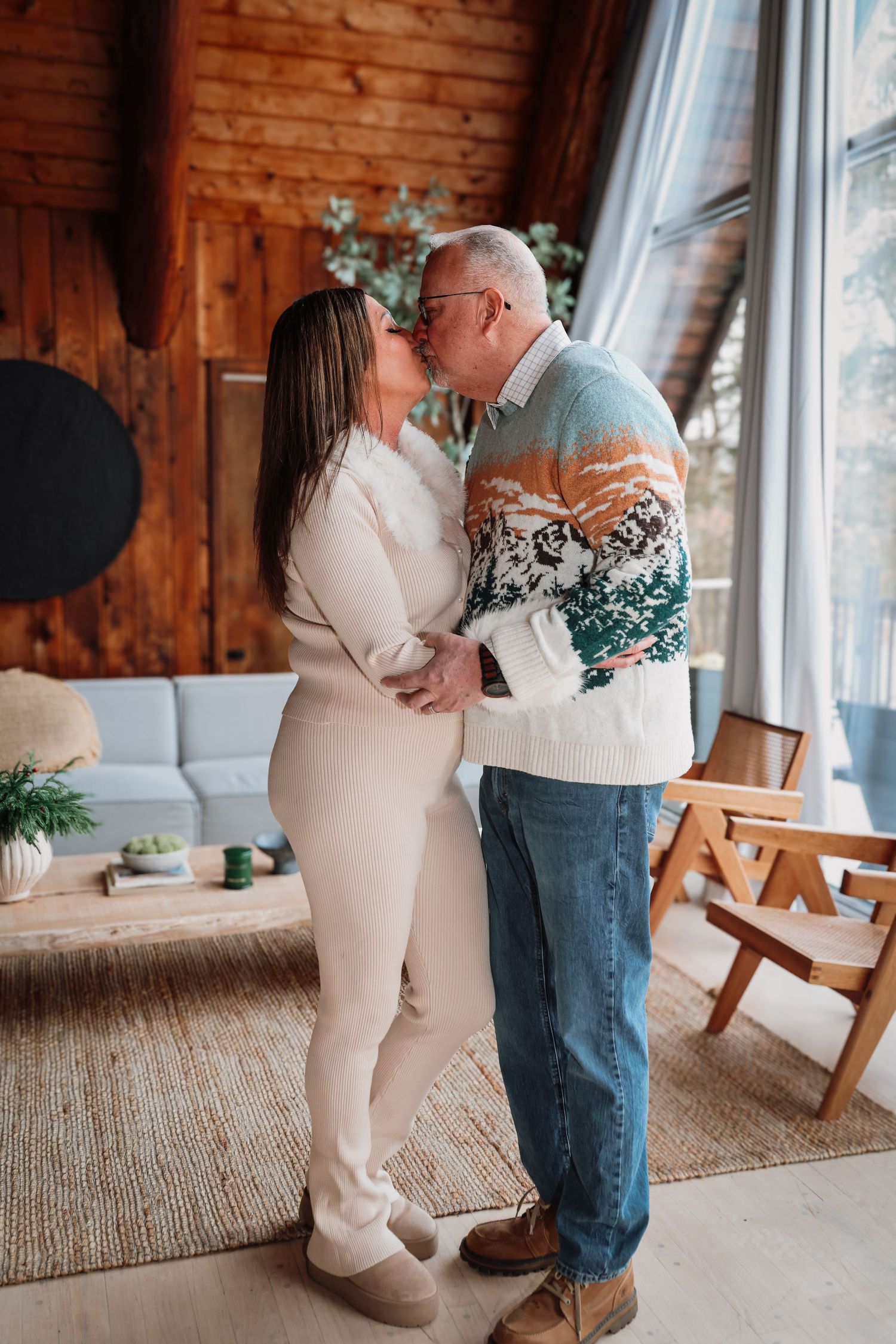 A couple shares an intimate dance moment in a rustic room with wooden walls and natural lighting.