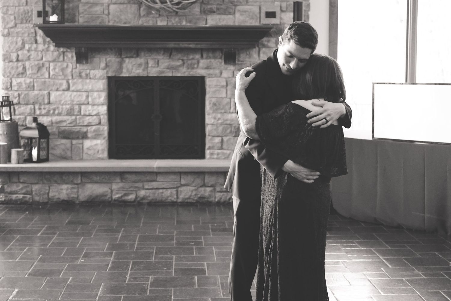 A series of black and white photos showing two people dancing together in a brick-walled room.