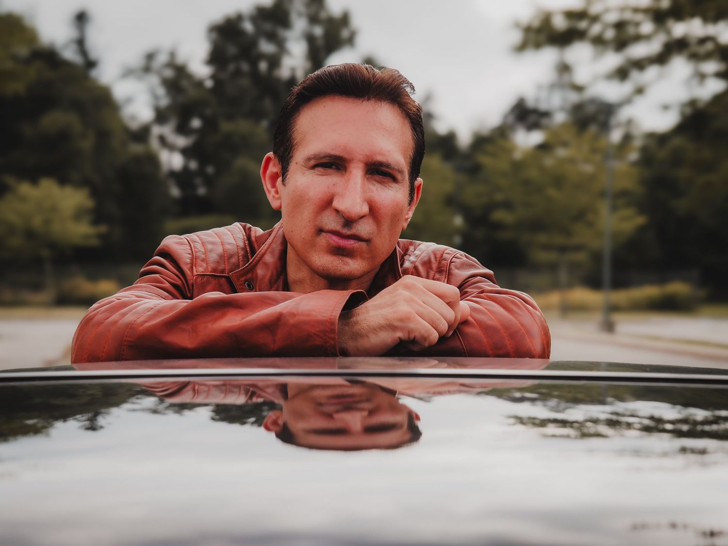 A series of similar shots showing someone in a red jacket leaning on a car window in an outdoor setting.