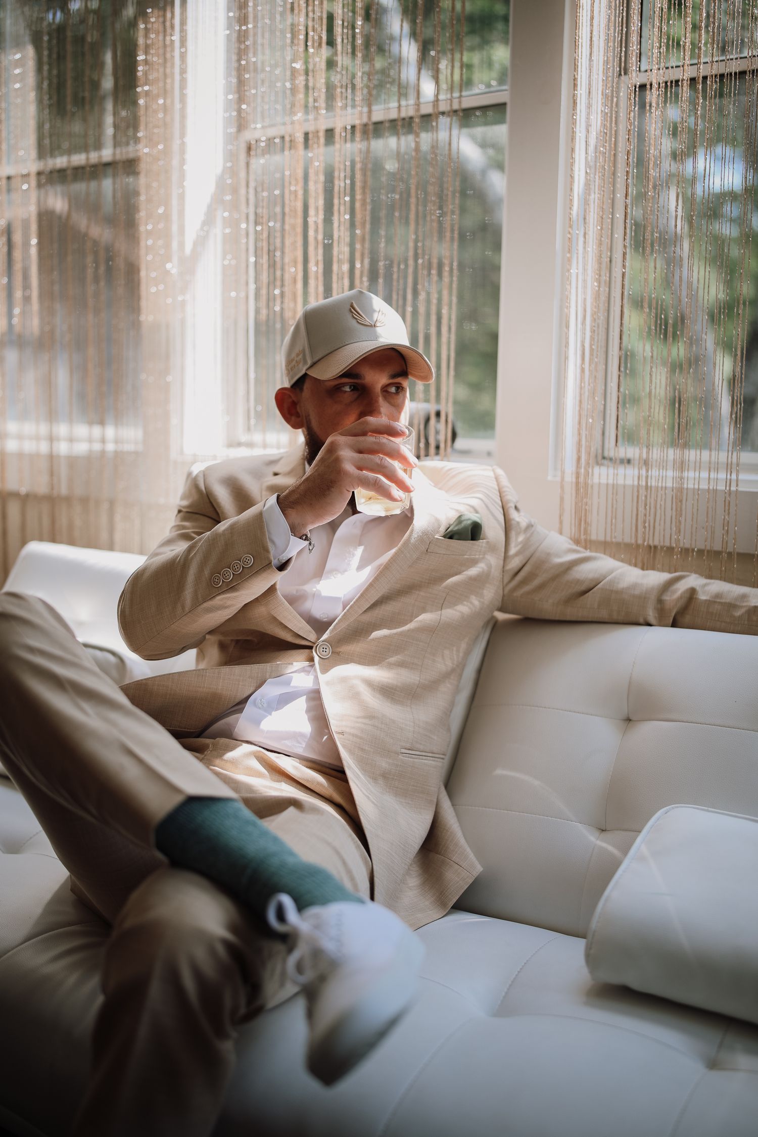 A series of five similar photos showing someone in white clothing reclining on a light-colored couch near windows.