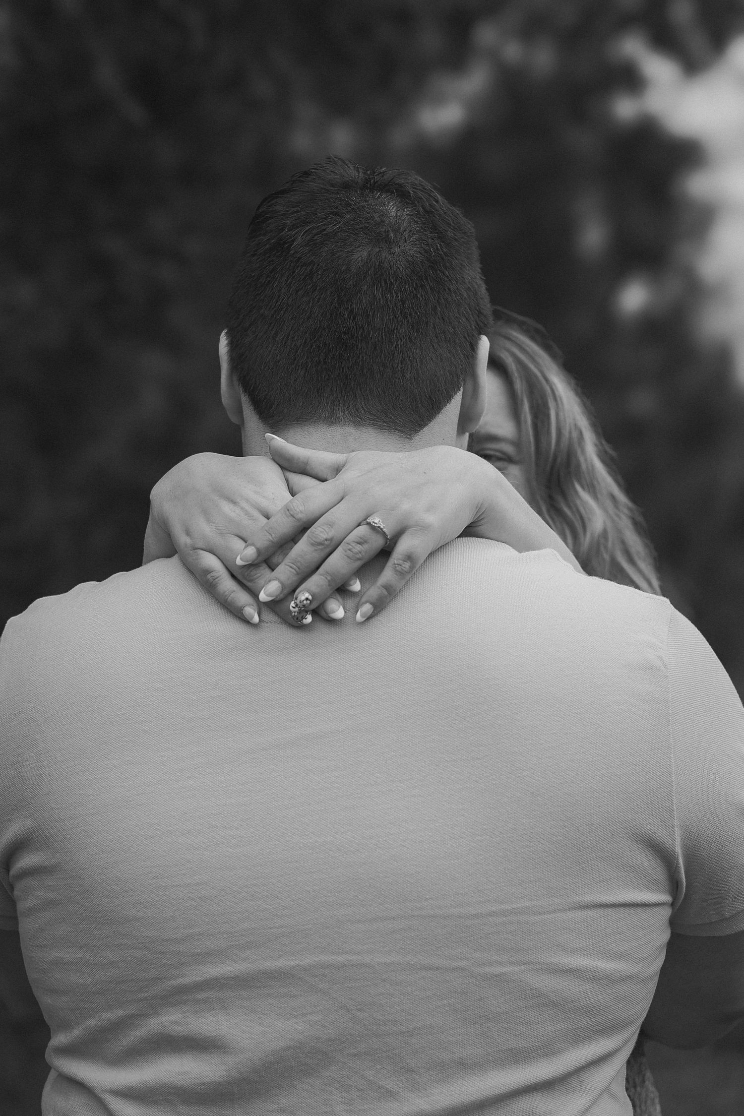 Black and white photo series showing a couple embracing from behind with hands around shoulders in an intimate moment.