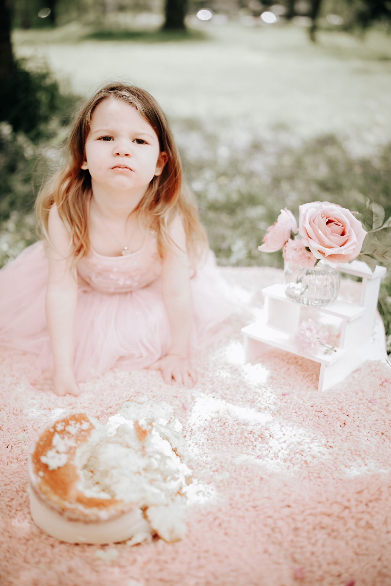 Dreamy pink-toned photo series showing a child in soft focus with delicate floral and tea party elements.