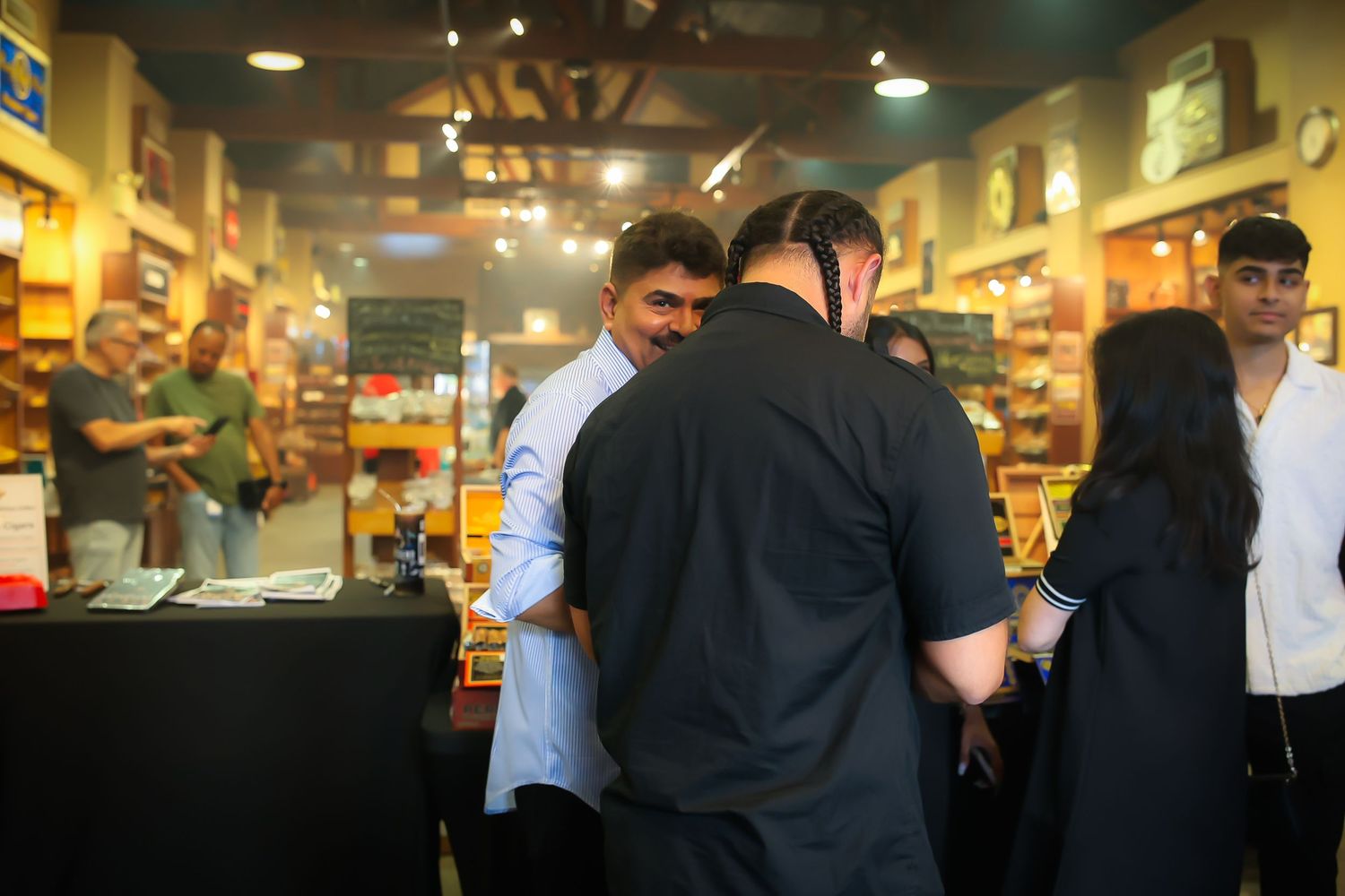 People browsing through books in a crowded bookstore with wooden shelves and warm lighting.