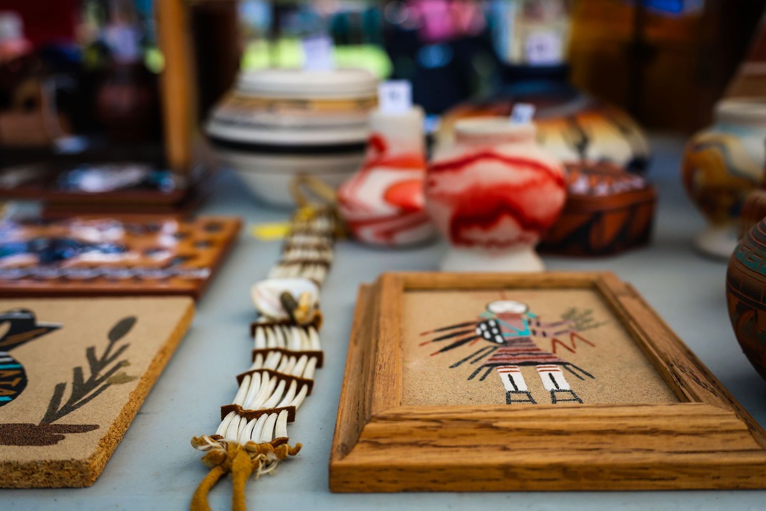 Native American art pieces featuring traditional Navajo sand painting designs displayed on wooden frames.