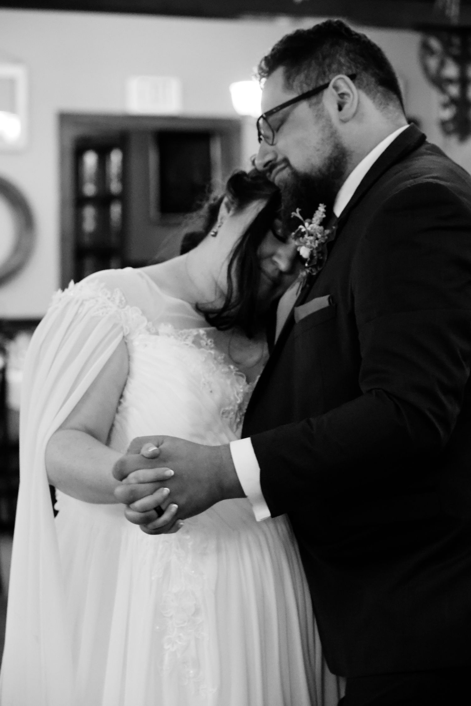 A romantic black and white photo series showing a couple sharing intimate kisses during their wedding ceremony.