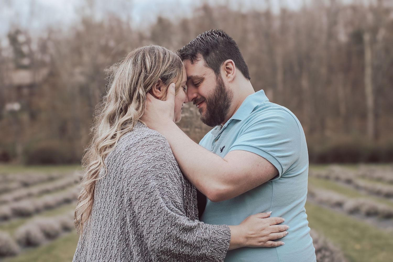 A romantic couple embraces in a lavender field during a golden hour photo session.