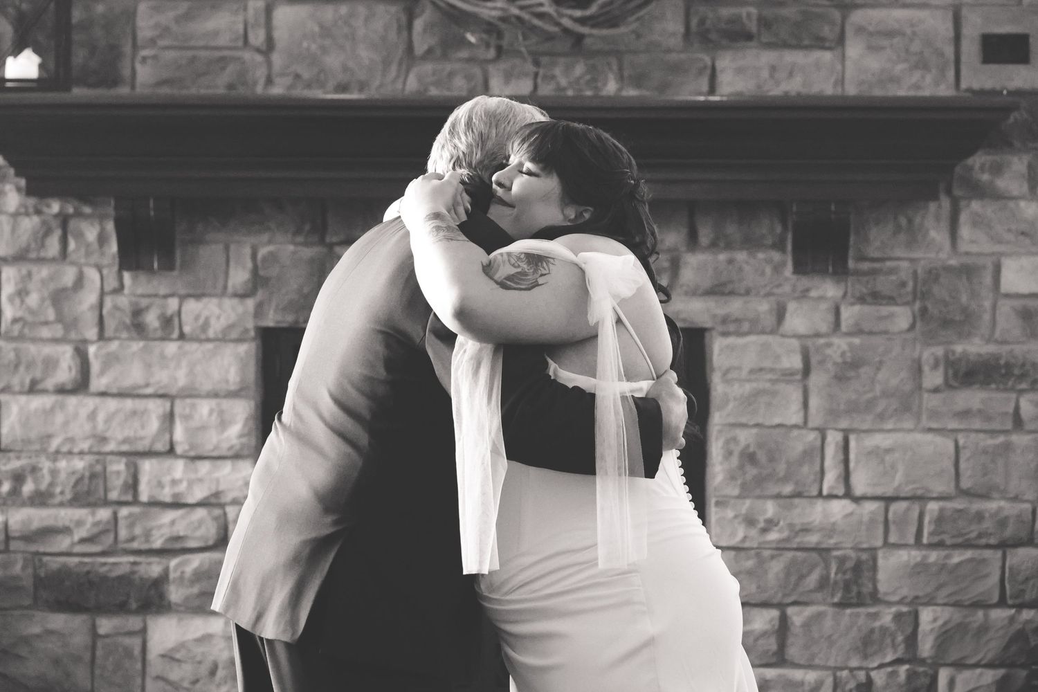 A black and white collage of wedding photos showing intimate moments between a couple against a brick wall background.