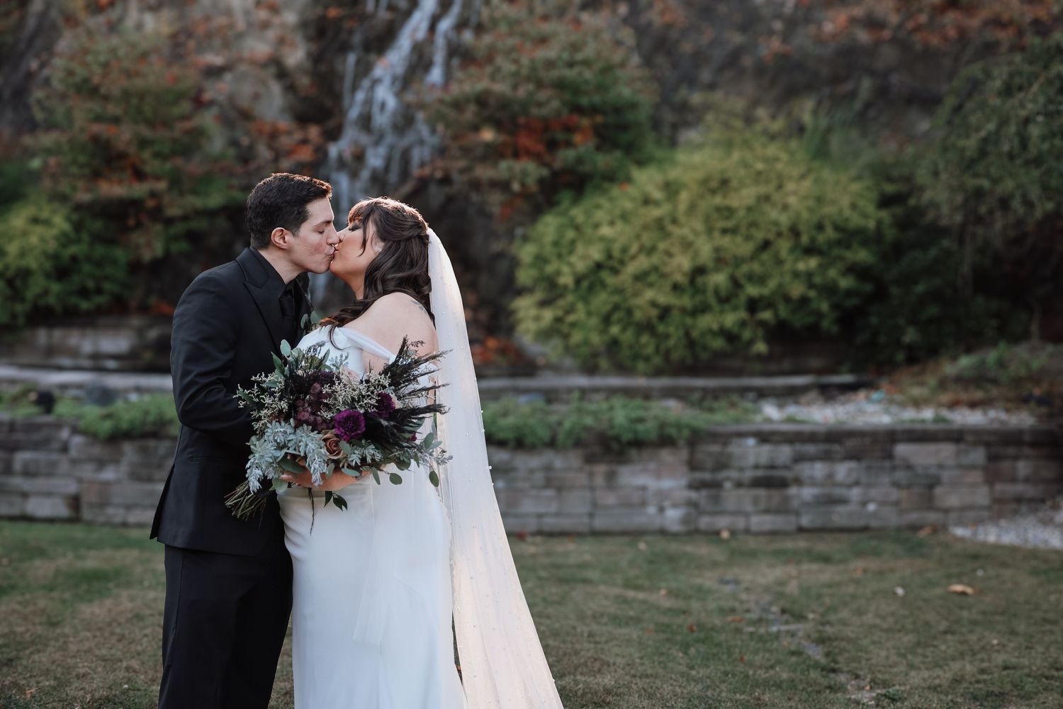 Newlyweds embracing in a natural outdoor setting with vibrant florals.