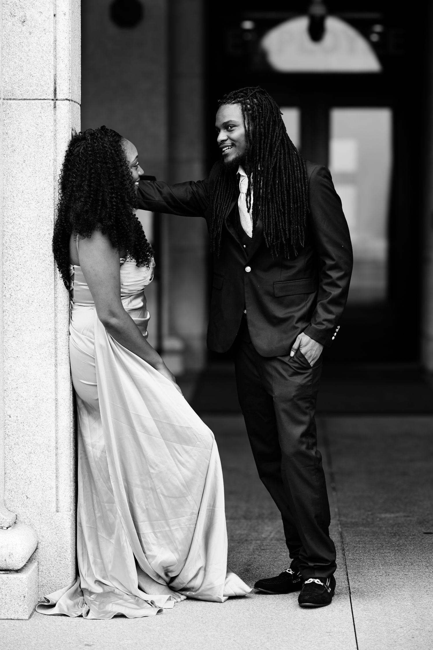 Black and white wedding photo series showing close-up details of bride in white dress and groom in dark suit.