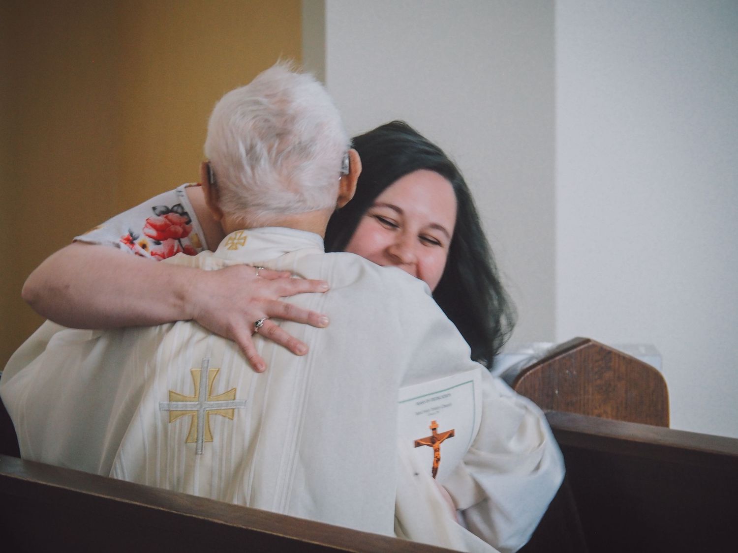 A series of four photos showing people embracing in emotional moments during a religious ceremony.