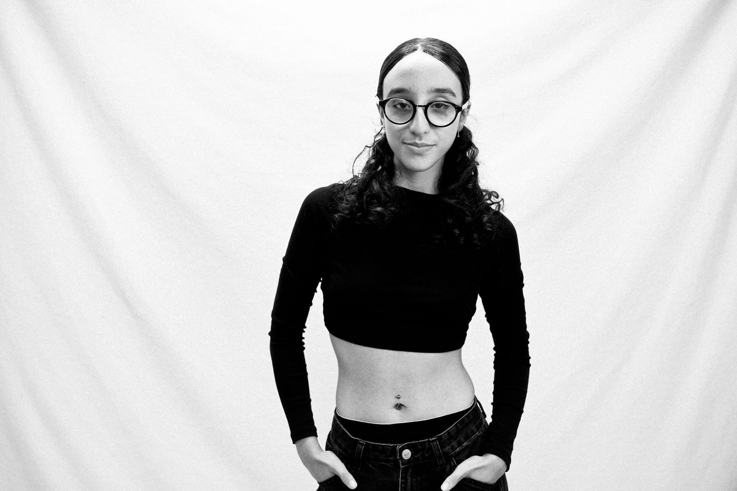 A black and white photo collage shows someone in glasses and dark clothing posing in different positions.