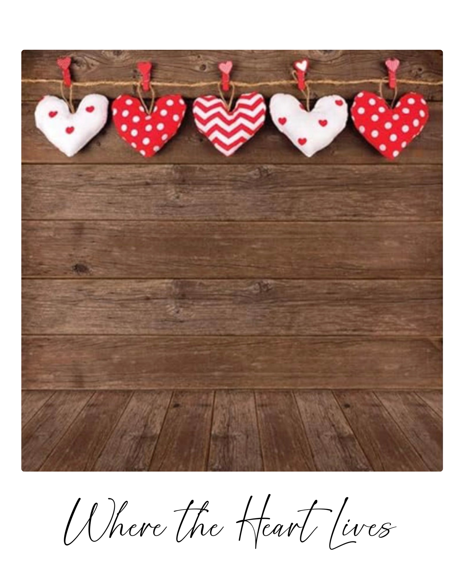 Red and white heart decorations hang on a string against a rustic wooden wall background with text 'Where the Heart Lives'.