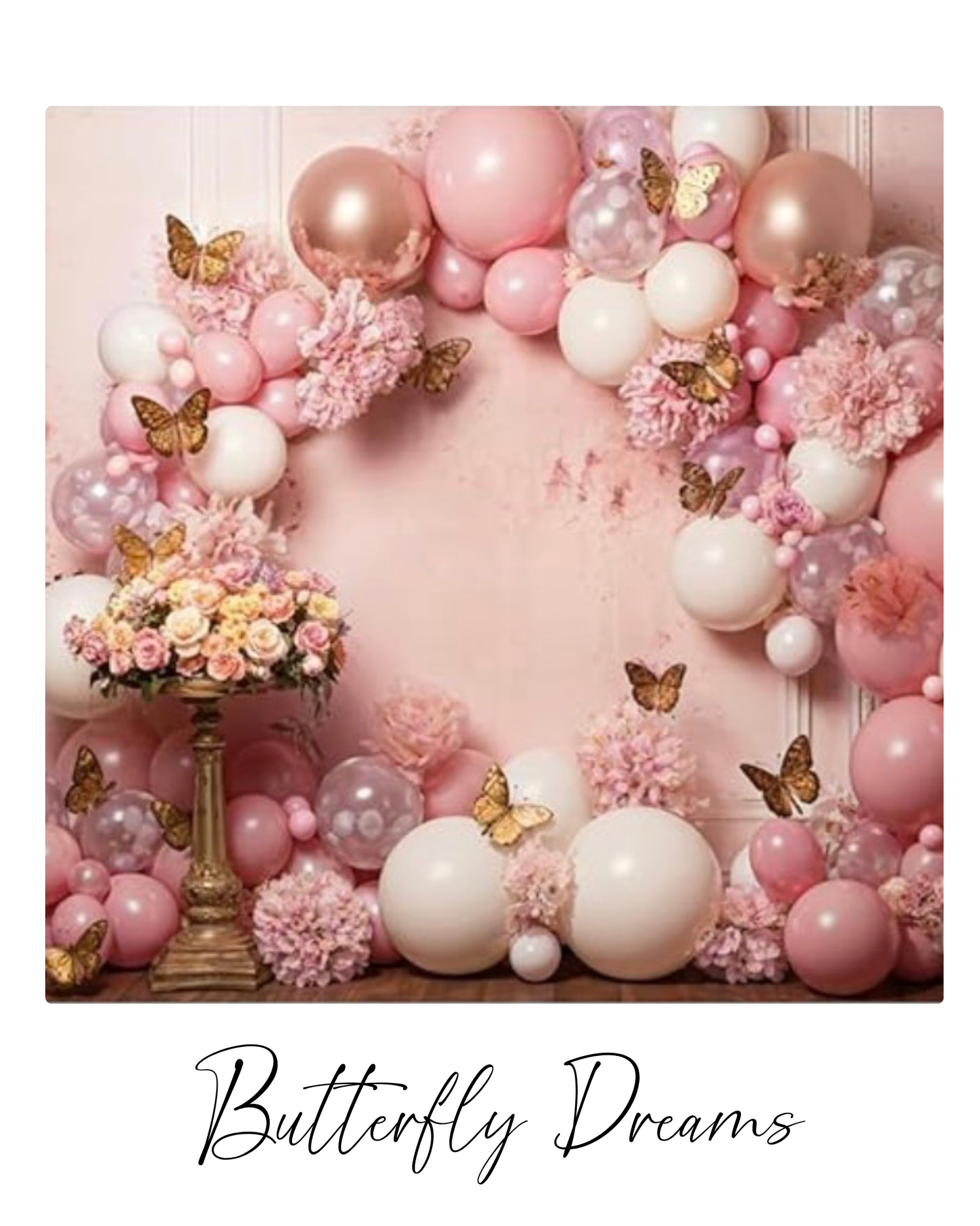 Elegant pink and rose gold balloon arch with butterflies and floral decorations against a blush pink backdrop.
