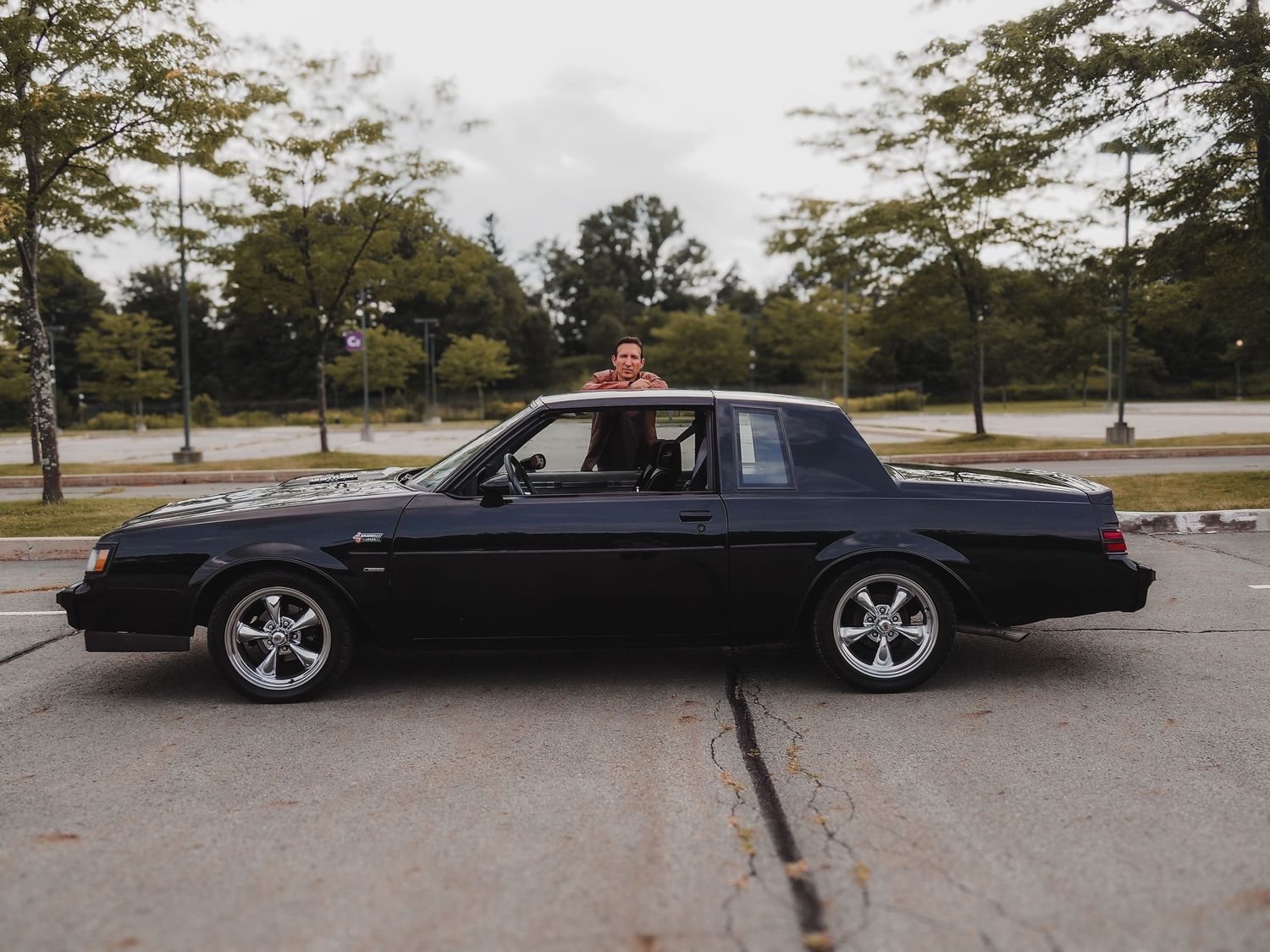 A sleek black convertible BMW photographed from multiple angles in a parking lot on an overcast day.