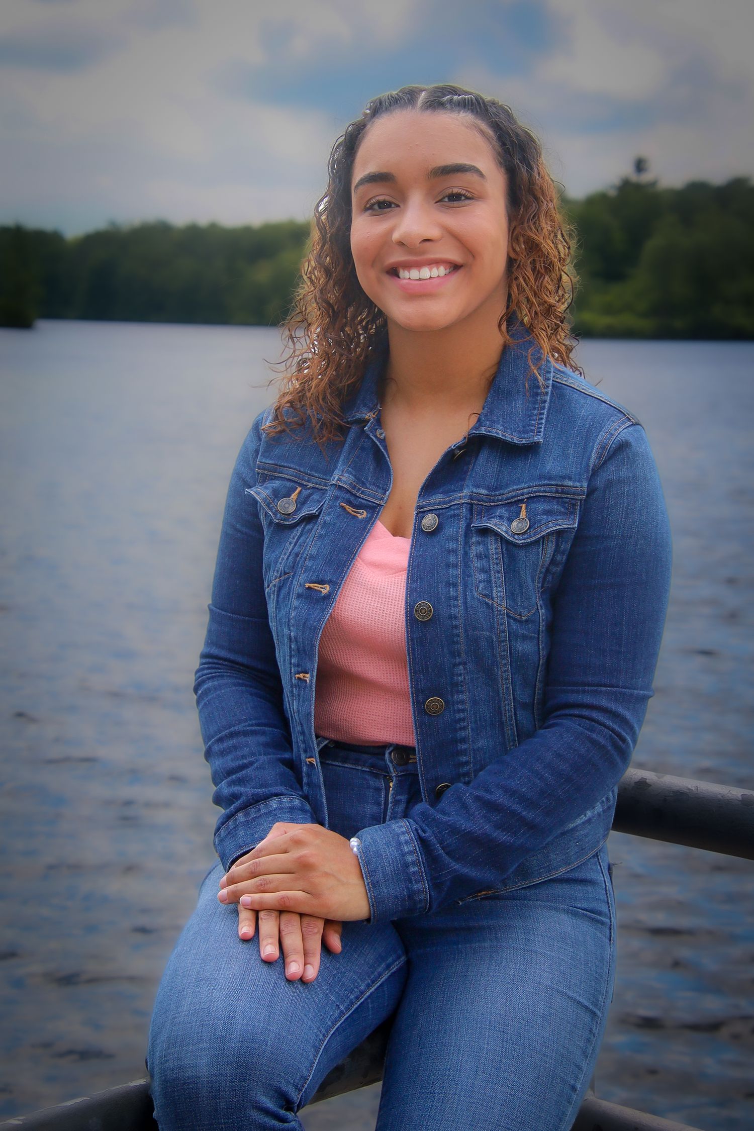 A person in denim jacket poses outdoors by a lake in a series of casual portraits.