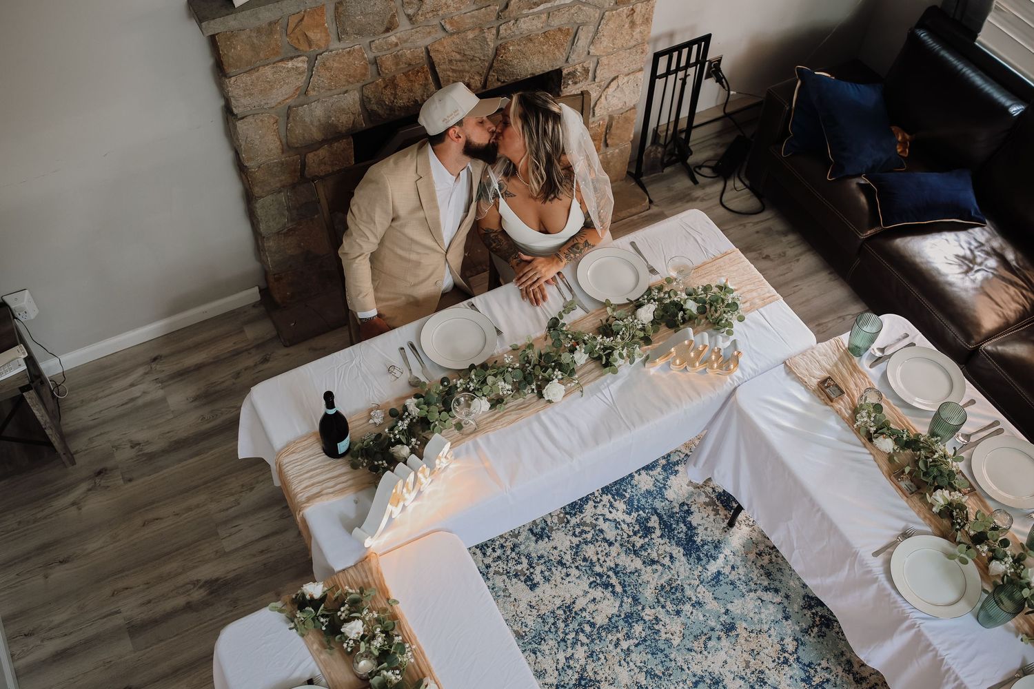 A rustic table setting features a blue and white patterned runner with delicate floral arrangements and place settings.