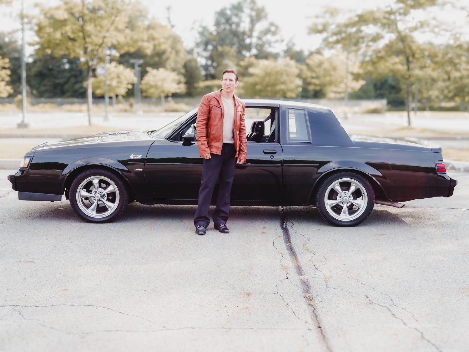 A custom lowrider car in maroon paint shown from multiple angles parked in a parking lot.