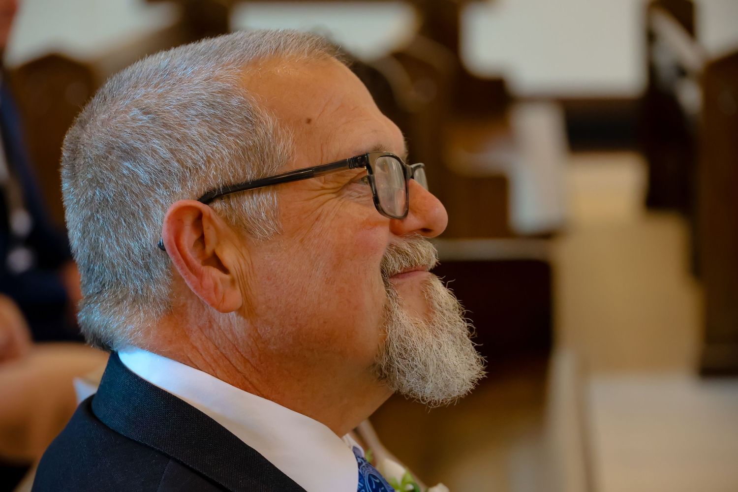 A series of profile shots showing a person with glasses and gray hair in various angles against a warm-toned background.