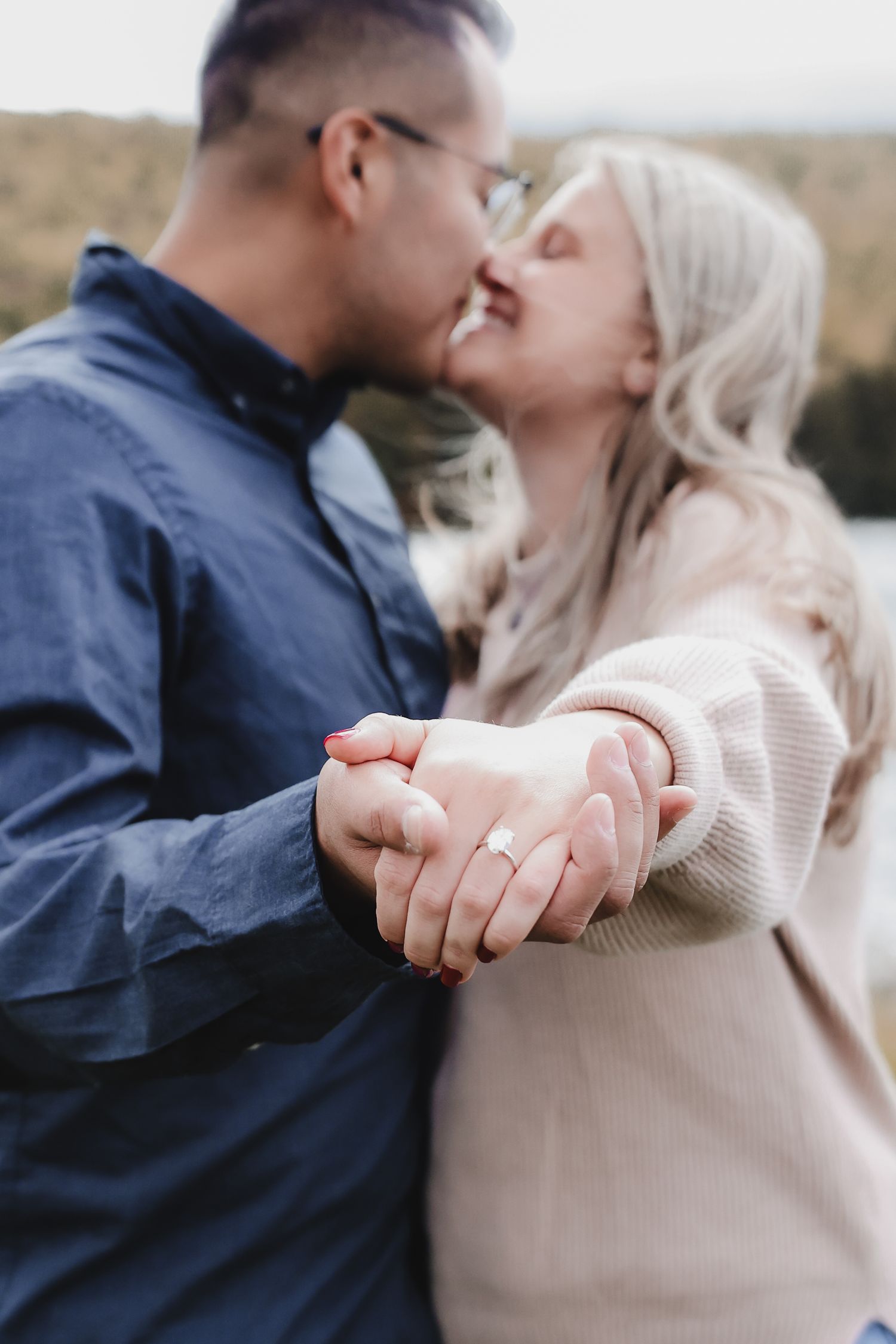 A couple shares an intimate moment while holding hands in a series of romantic engagement-style photos.