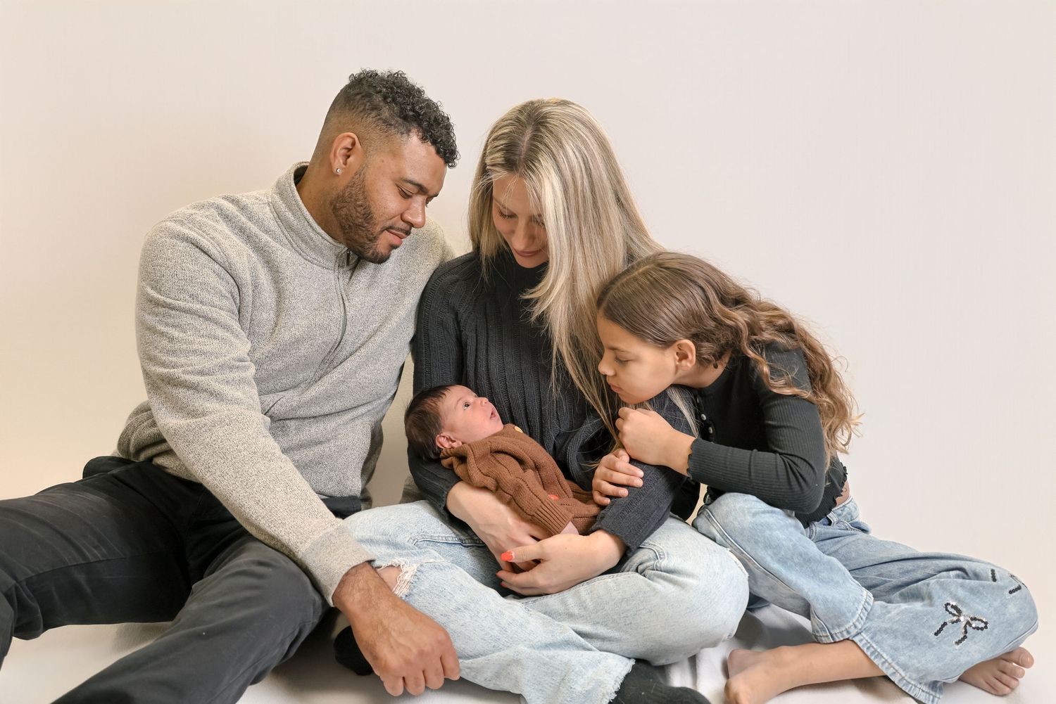 A loving family shares tender moments together while relaxing on a cozy bed.
