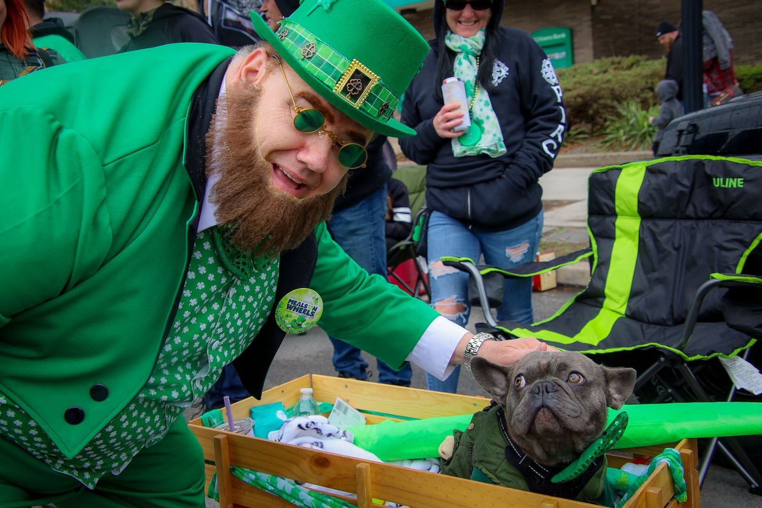 People dressed in green celebrating St Patrick's Day at an outdoor festival with food and drinks.