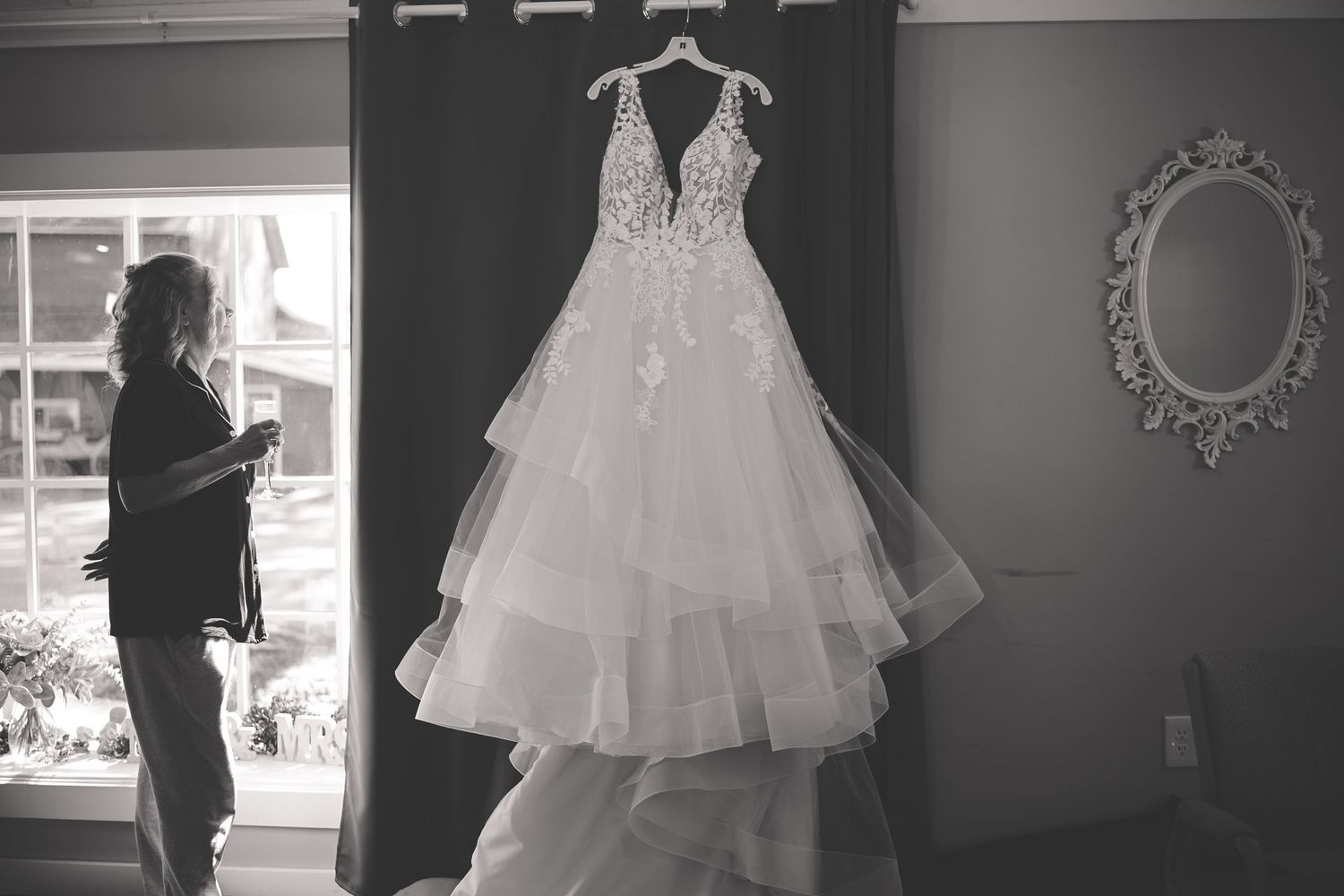 A series of black and white photos showing wedding dress preparations with elegant white gowns and silhouettes.
