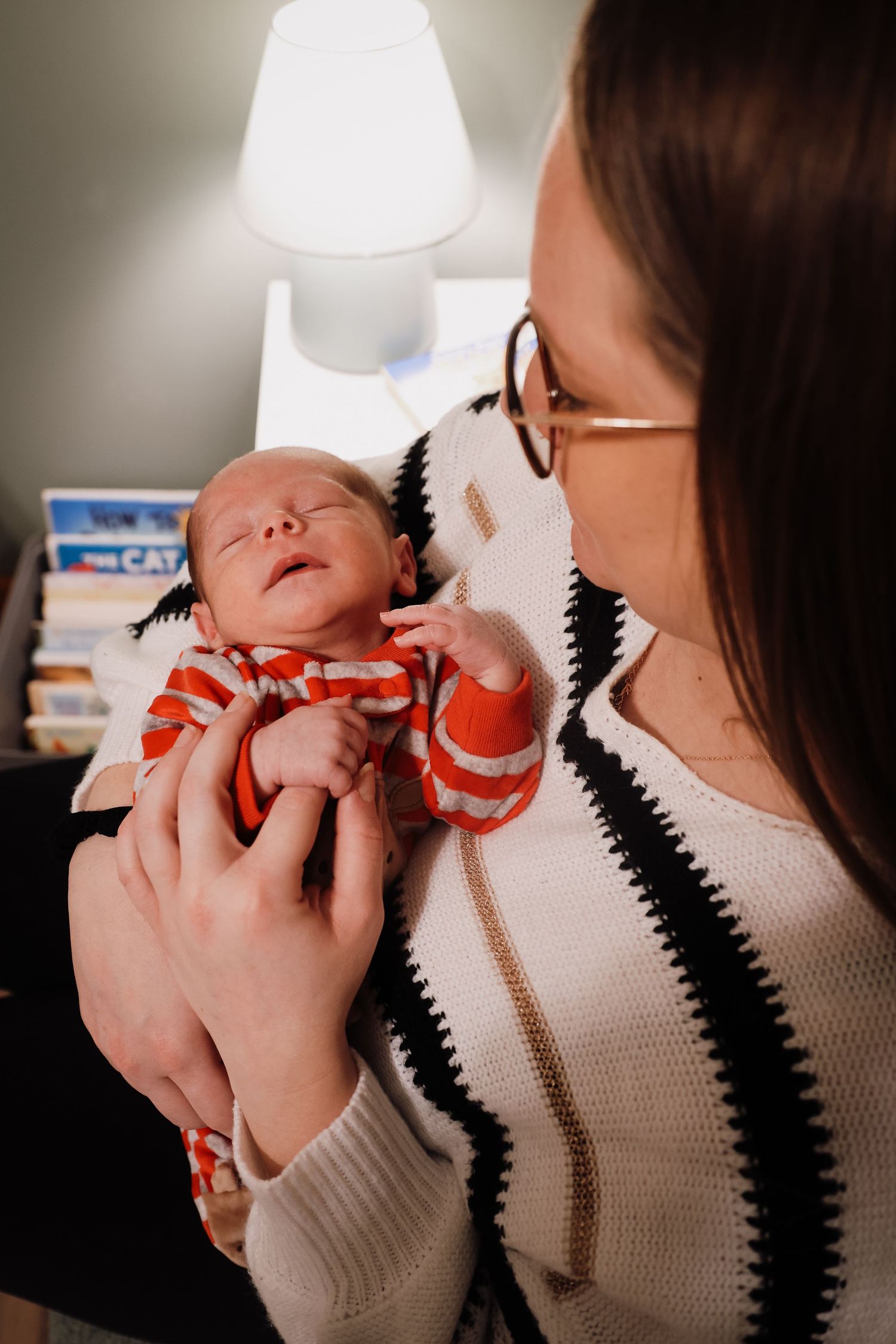 A series of photos showing a sleeping infant being held in a striped sweater against a soft background.
