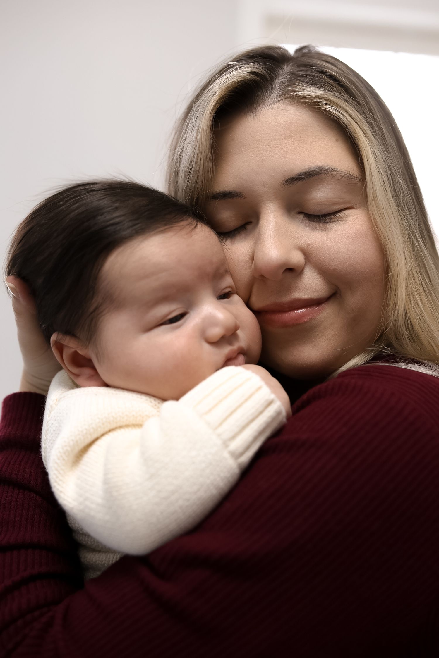 A series of tender moments showing affection and closeness between two people wearing a burgundy sweater and white mask.
