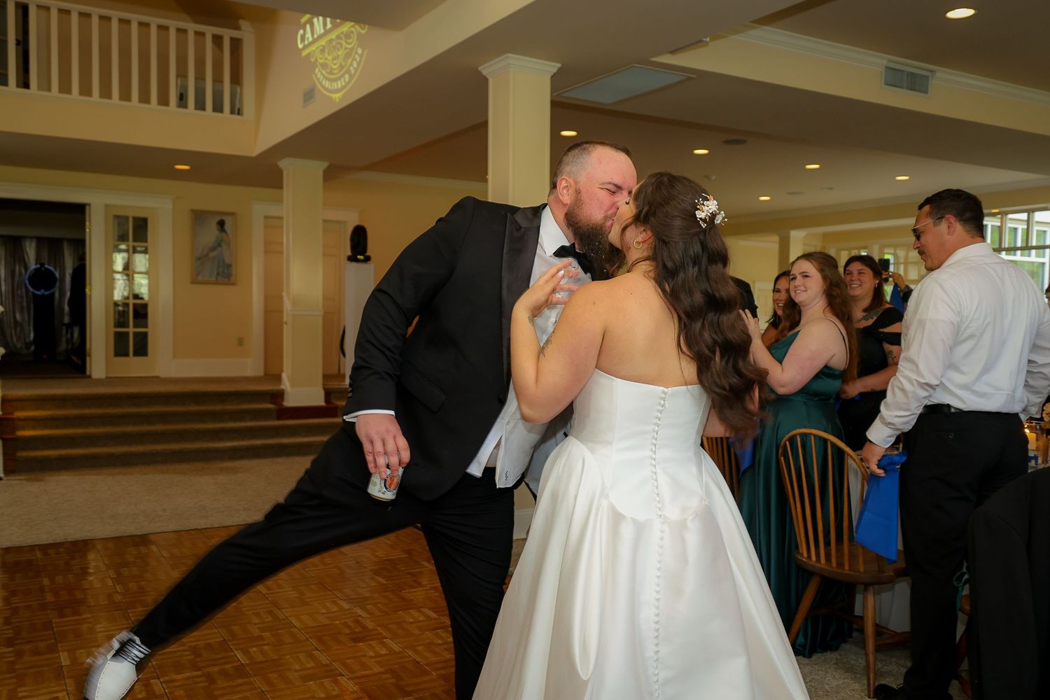 Bride and groom share a romantic kiss during their first dance at an elegant wedding reception venue.