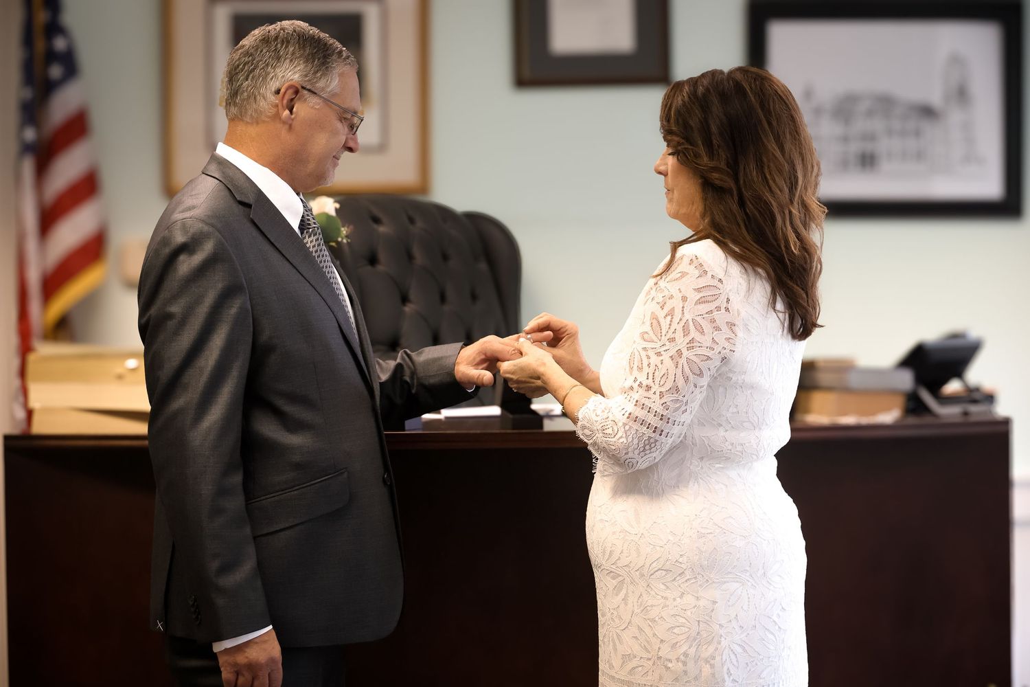 A couple stands at a courthouse counter during what appears to be a civil marriage ceremony.