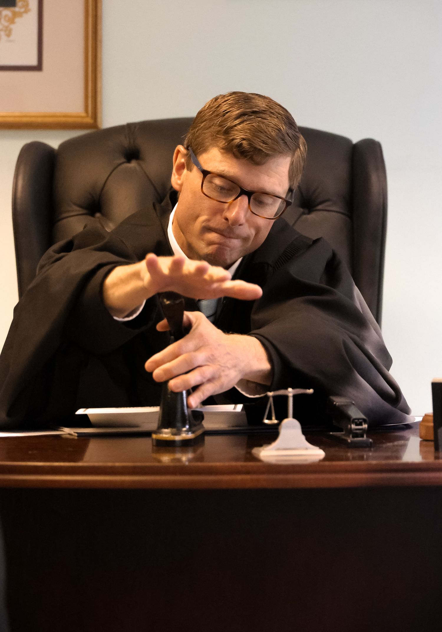 A person in a business suit slumps over asleep at a desk in a series of four sequential photos.
