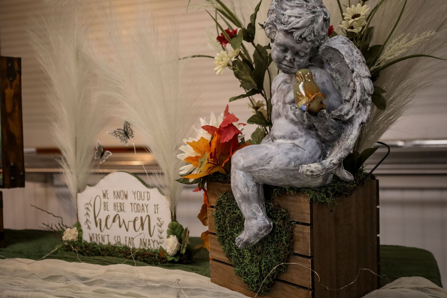 A series of fall themed home decor items including floral arrangements and rustic signs arranged in a cozy display.