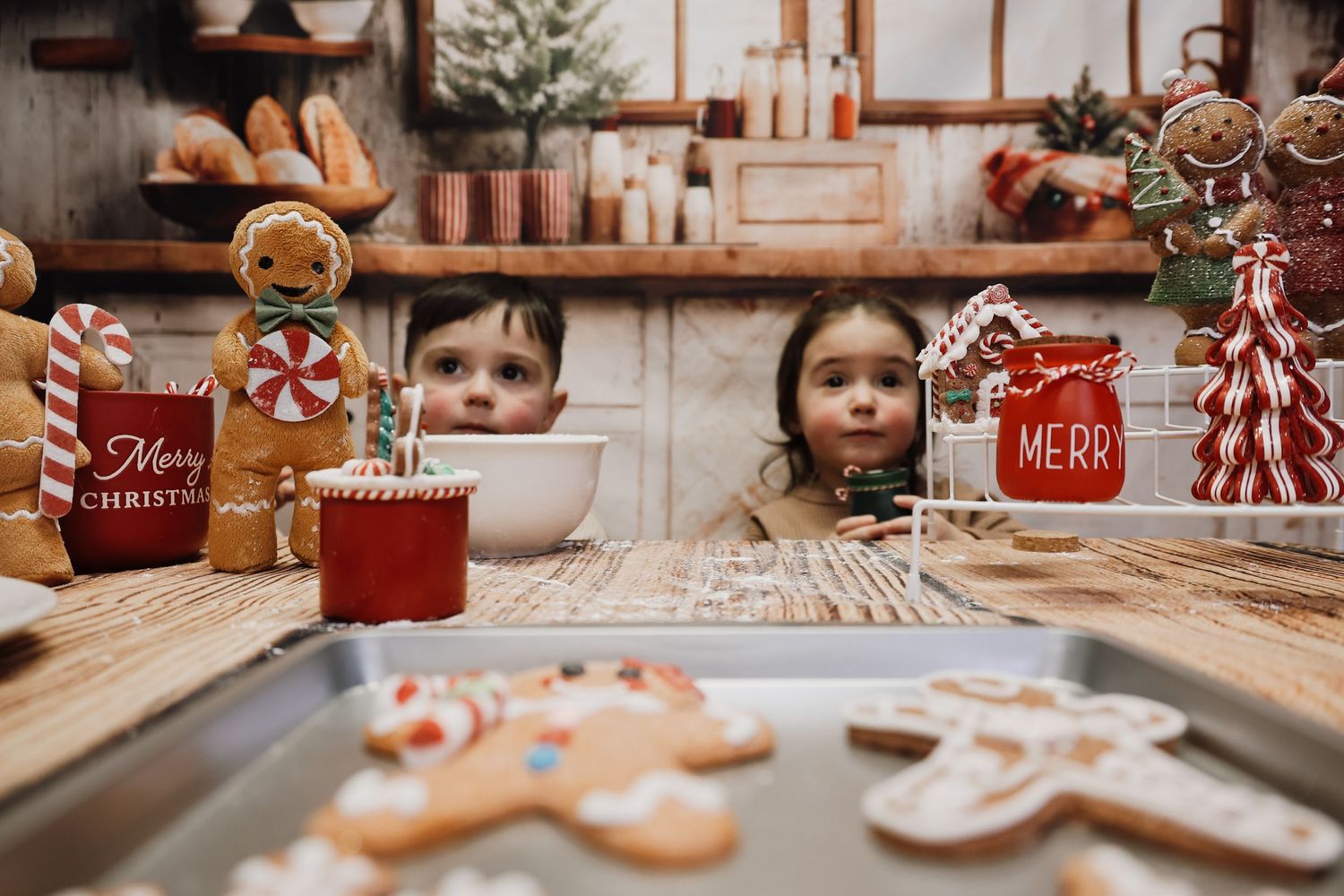 A cozy Christmas scene with red decorative items, candy canes, and festive holiday decor arranged on wooden surfaces.