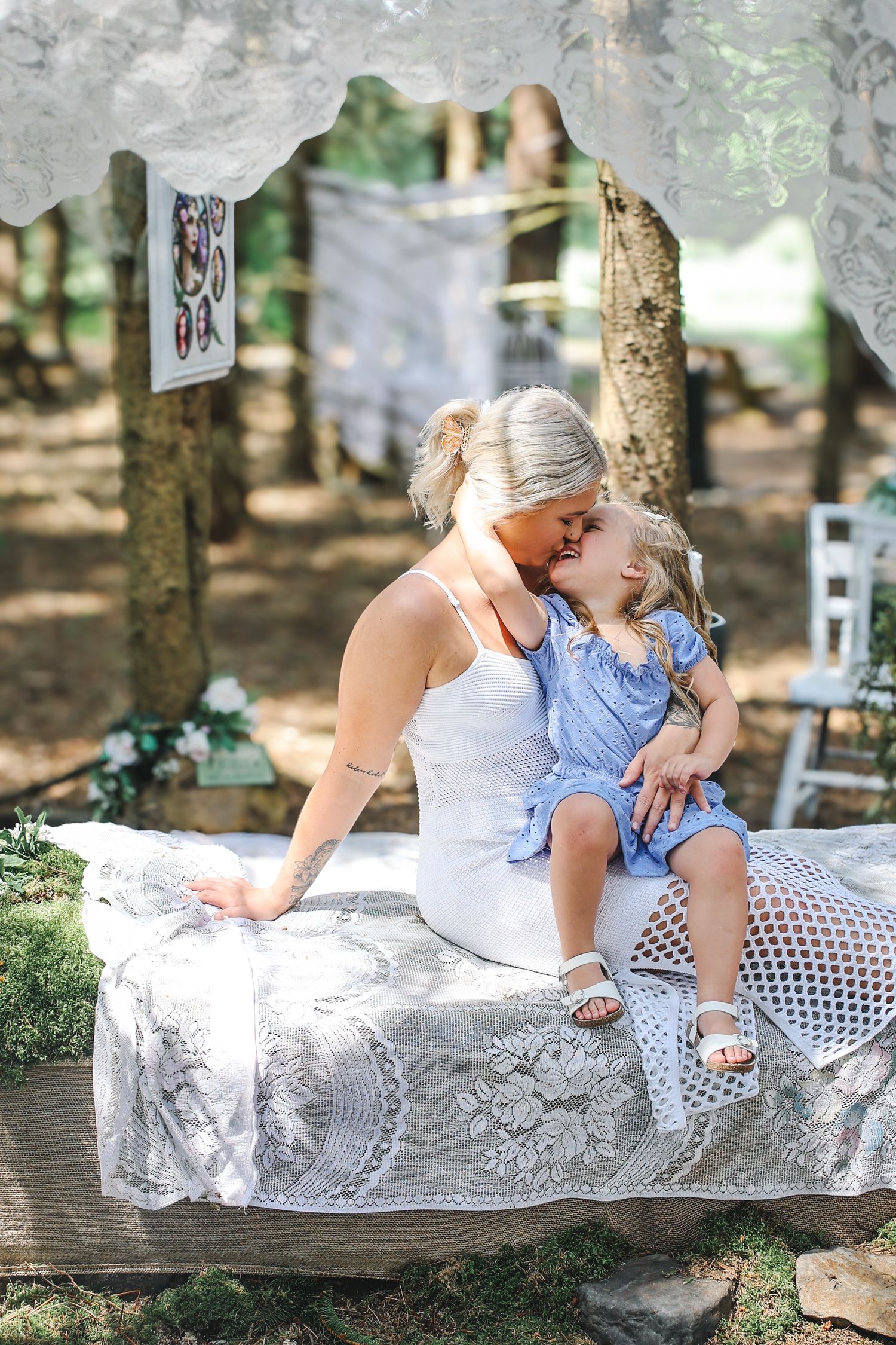 A tender moment shared on a lace-covered bench in a sunlit outdoor setting.