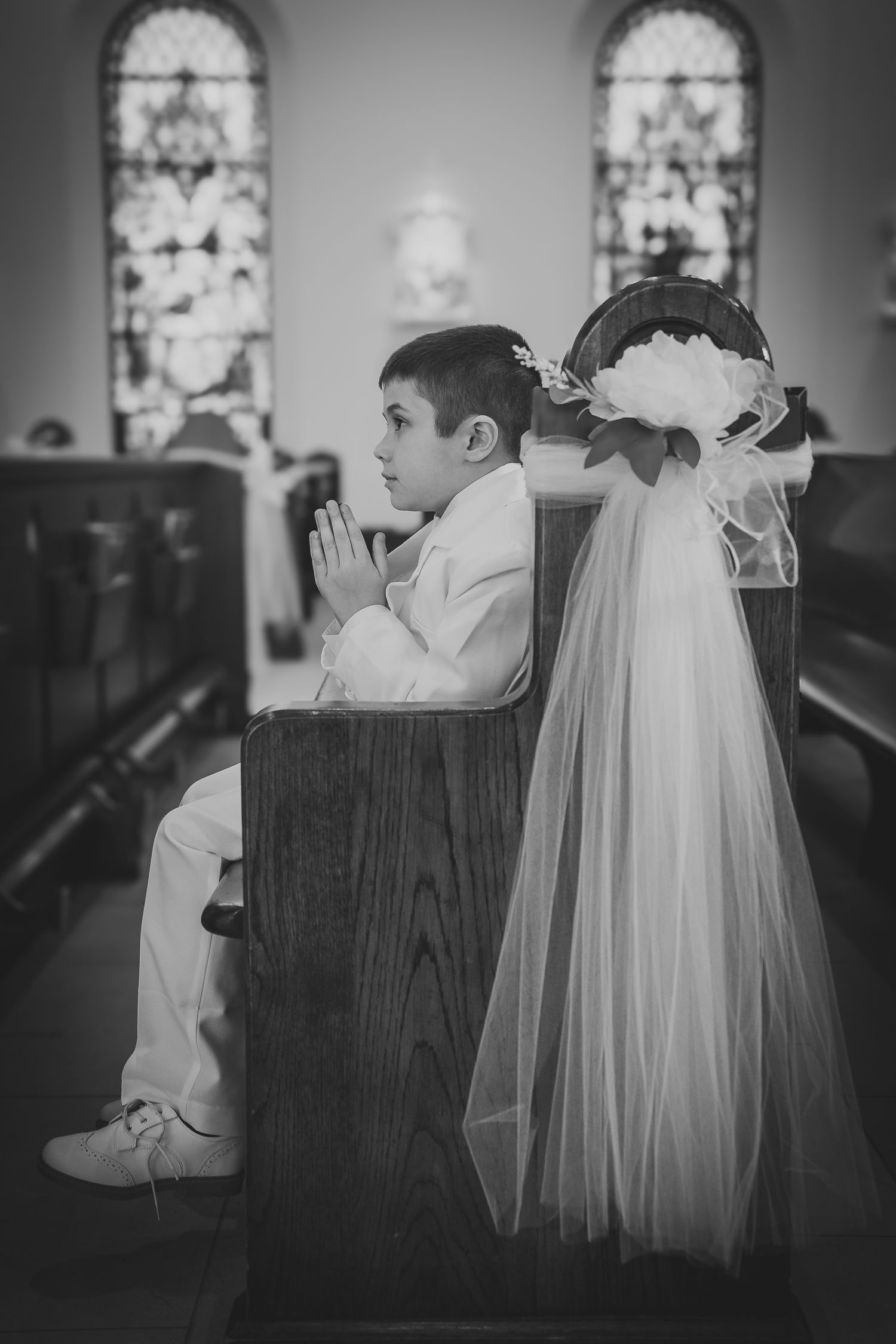 A black and white photo series showing a child in church pews with a white baptismal gown displayed beside them.