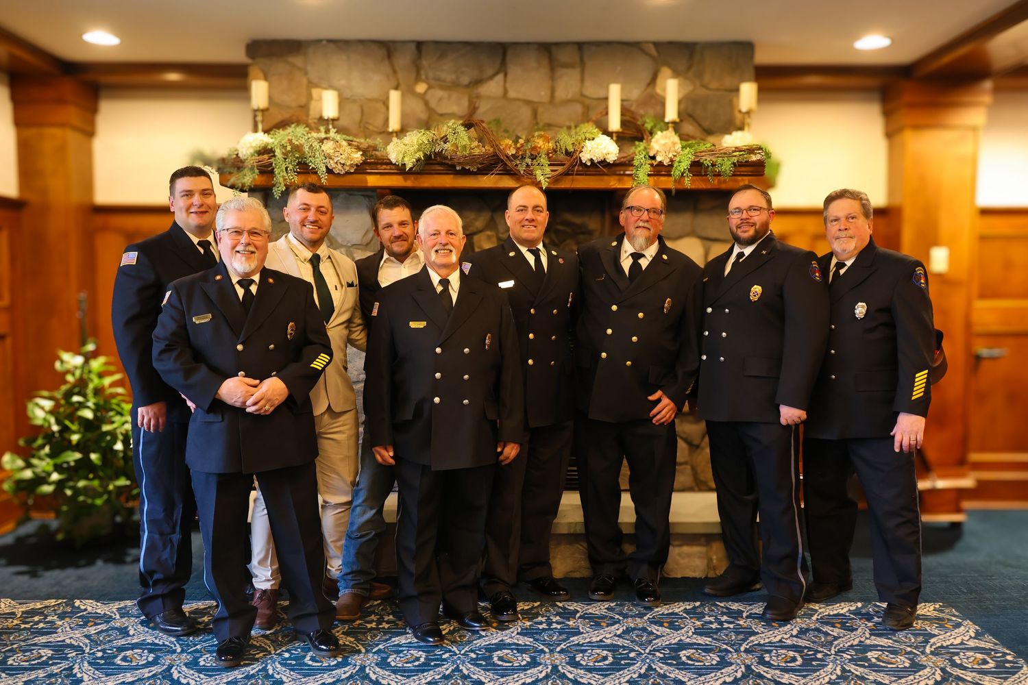 Group of uniformed officers stand together in formal arrangement during holiday ceremony with festive decorations.