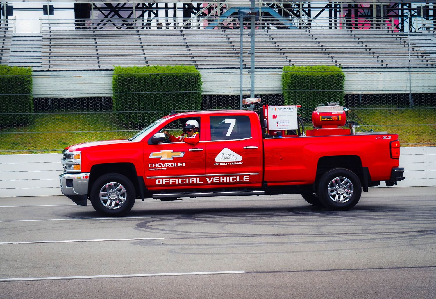 Red emergency response pickup trucks parked in a row at an outdoor facility.