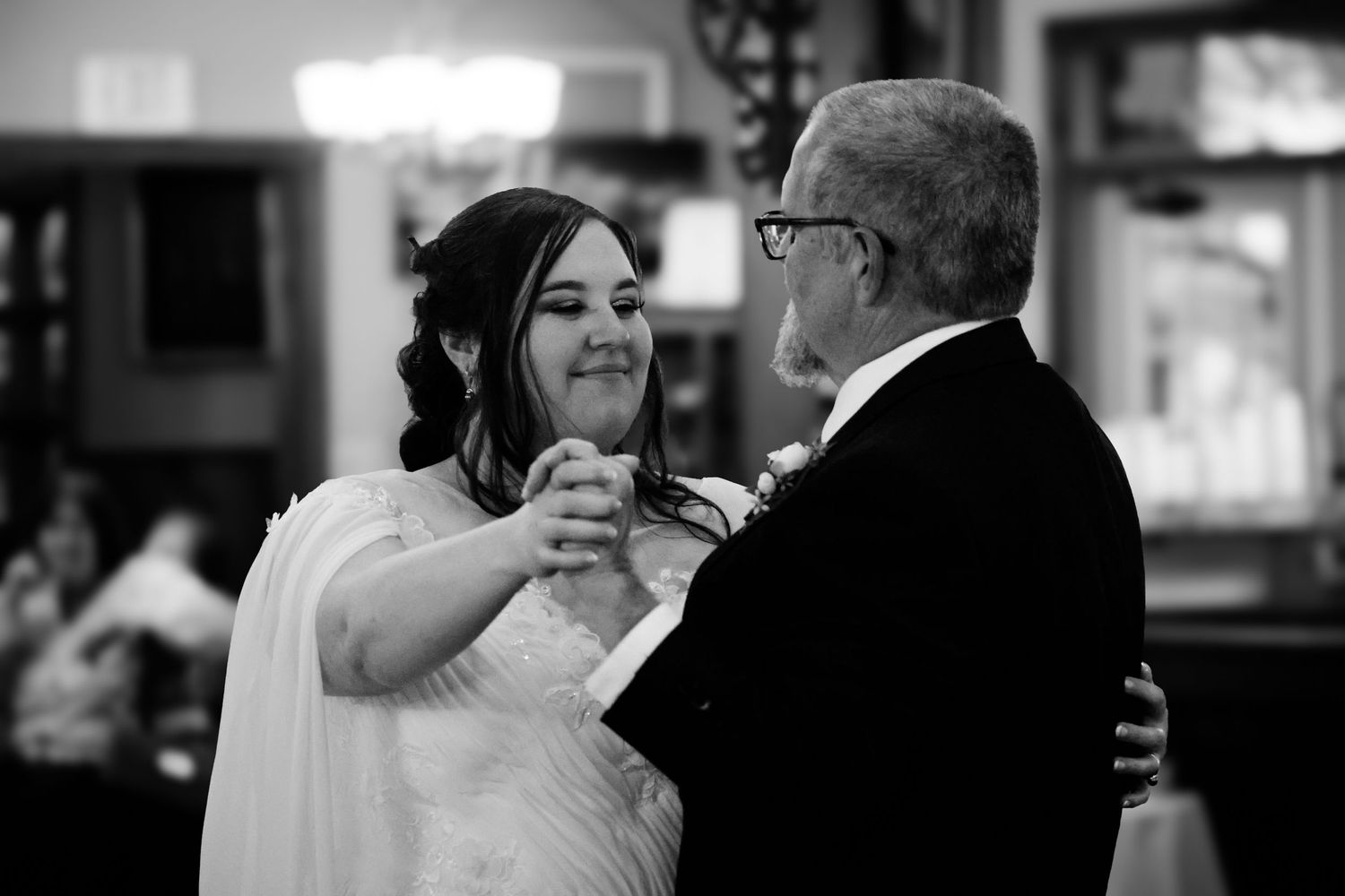 A father and daughter share an emotional dance together at a wedding reception.
