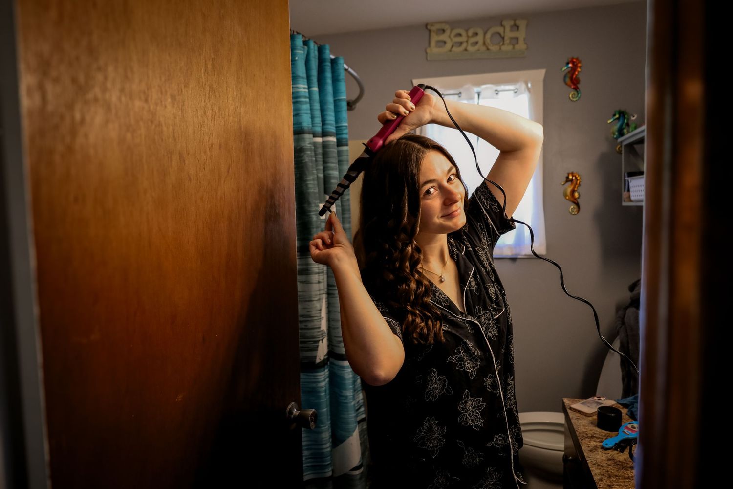 A sequence of four moody photos showing a person with long dark hair against a warm wooden wall.