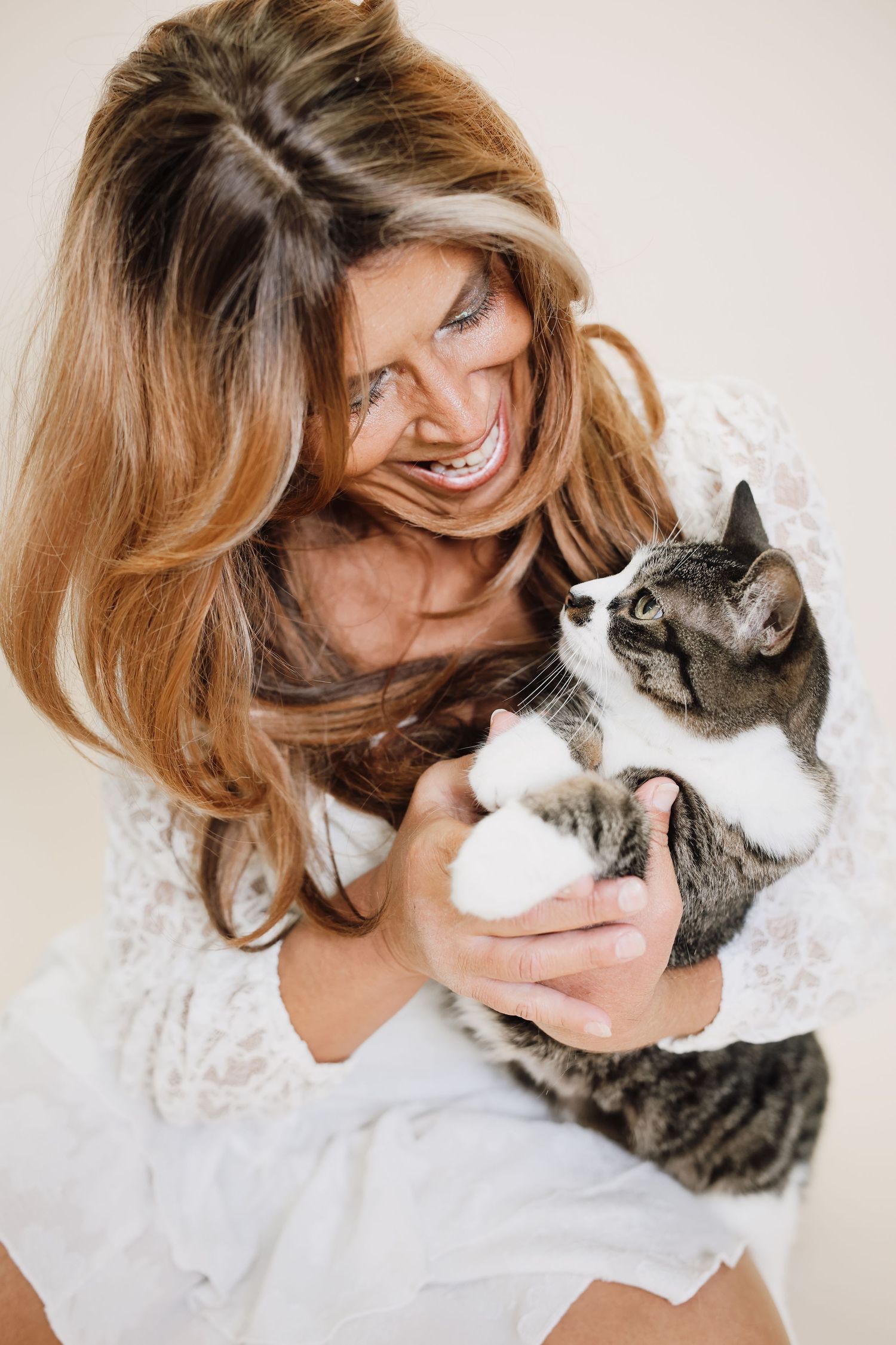 A series of tender moments between a woman in white and her grey tabby cat showing their loving bond.