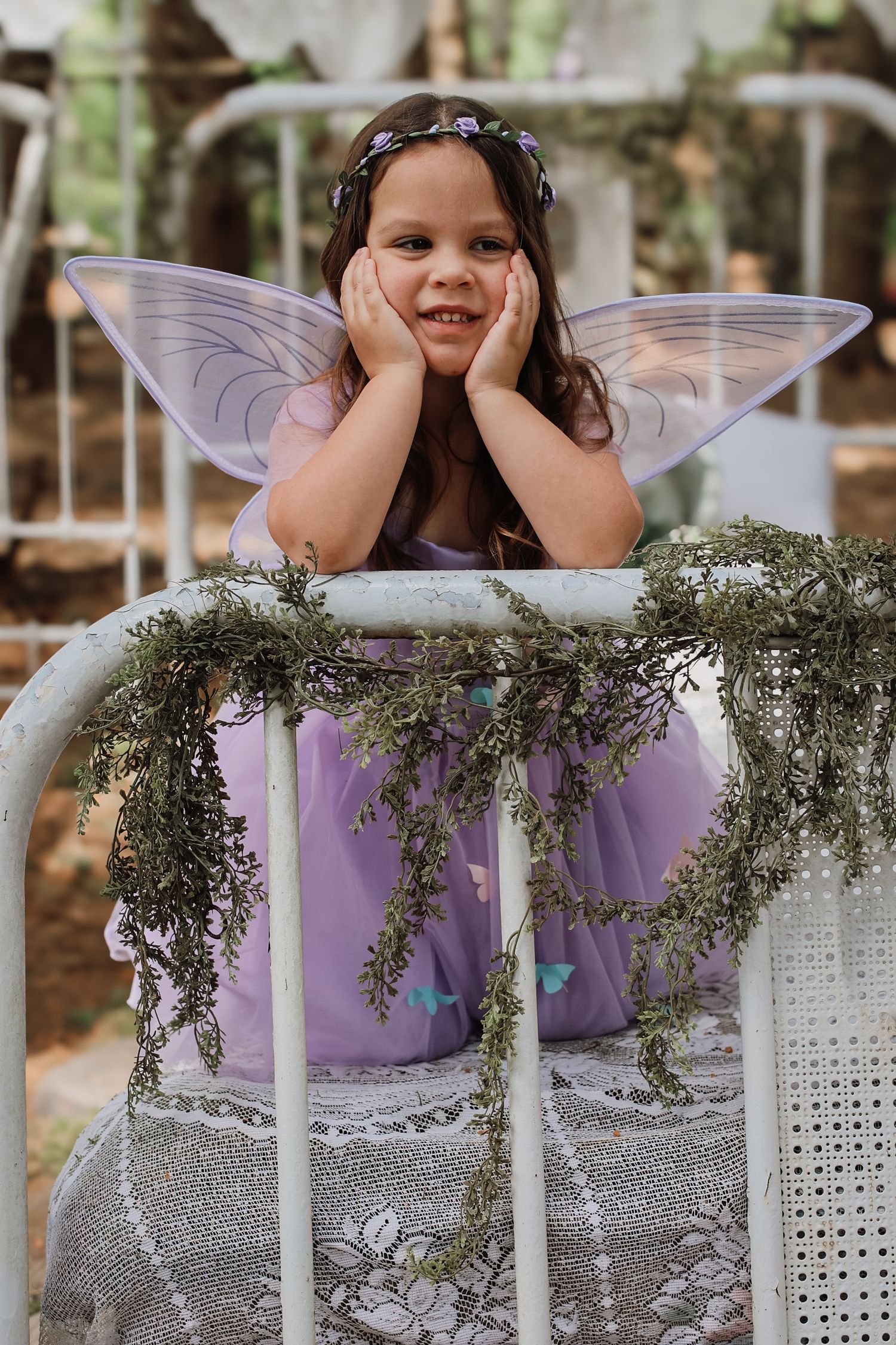 A series of whimsical fairy-themed photos showing someone wearing wings posing behind decorative white lattice panels.