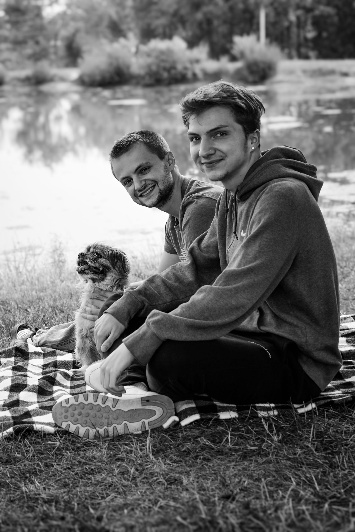 Three black and white photographs show people relaxing on grass in casual outdoor settings.