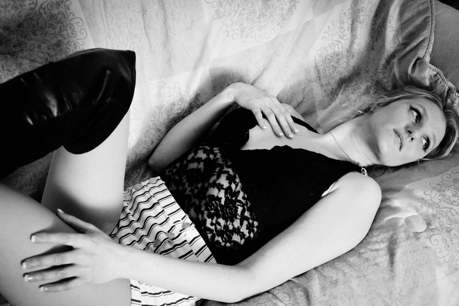 A series of black and white artistic photographs showing someone reclining in moody lighting and dramatic poses.