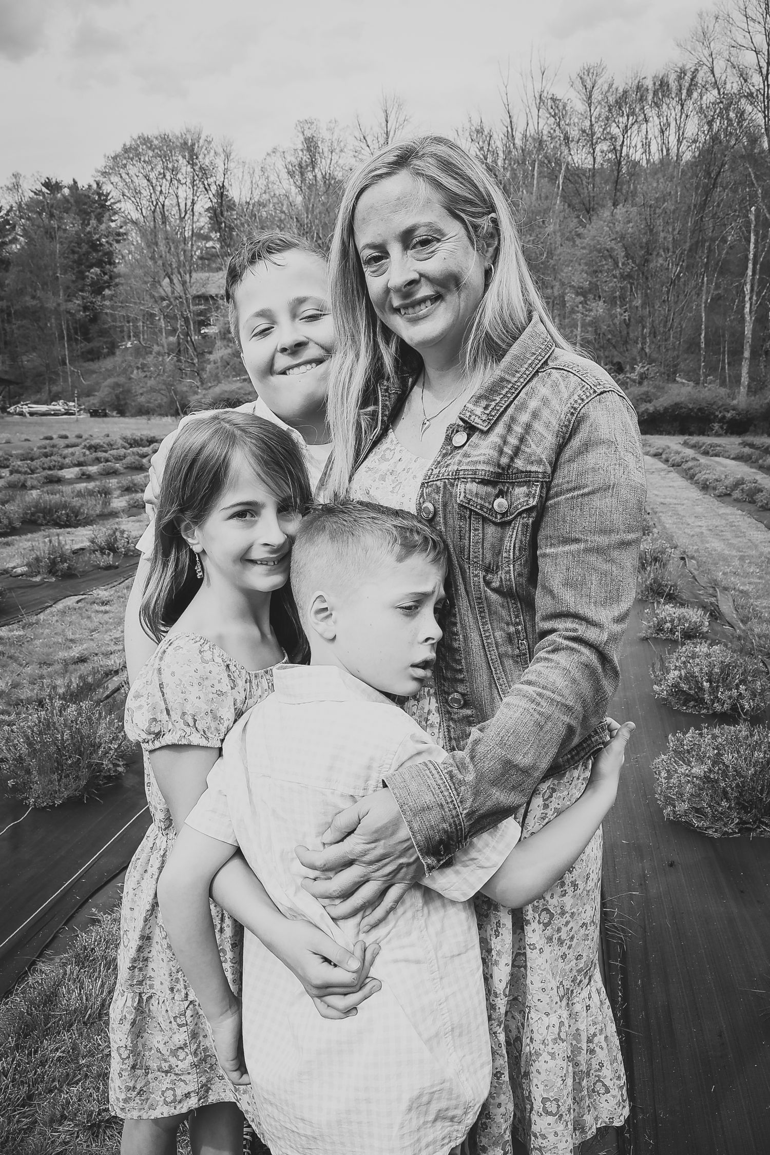 A family shares tender moments together by a serene pond on a spring afternoon.