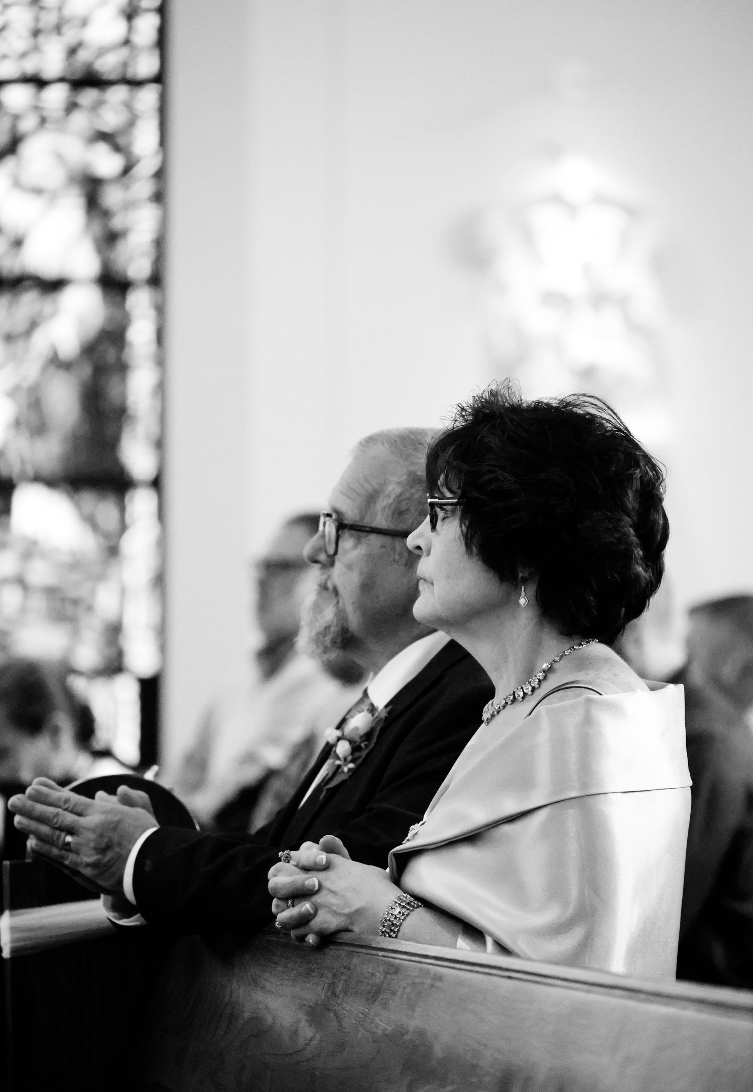 Black and white image of people sitting in church pews during a service.